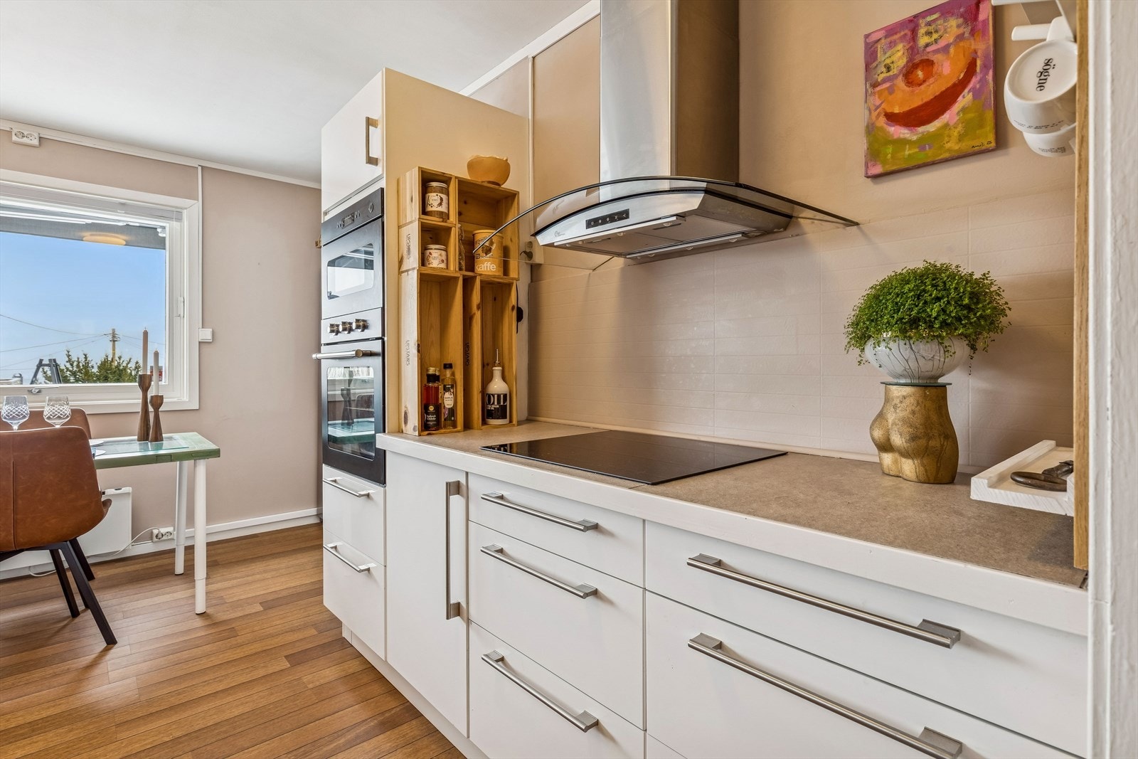 Et pent og bruksvennlig kjøkken. Malte fliser over benk i veggfargen. Galleribilde