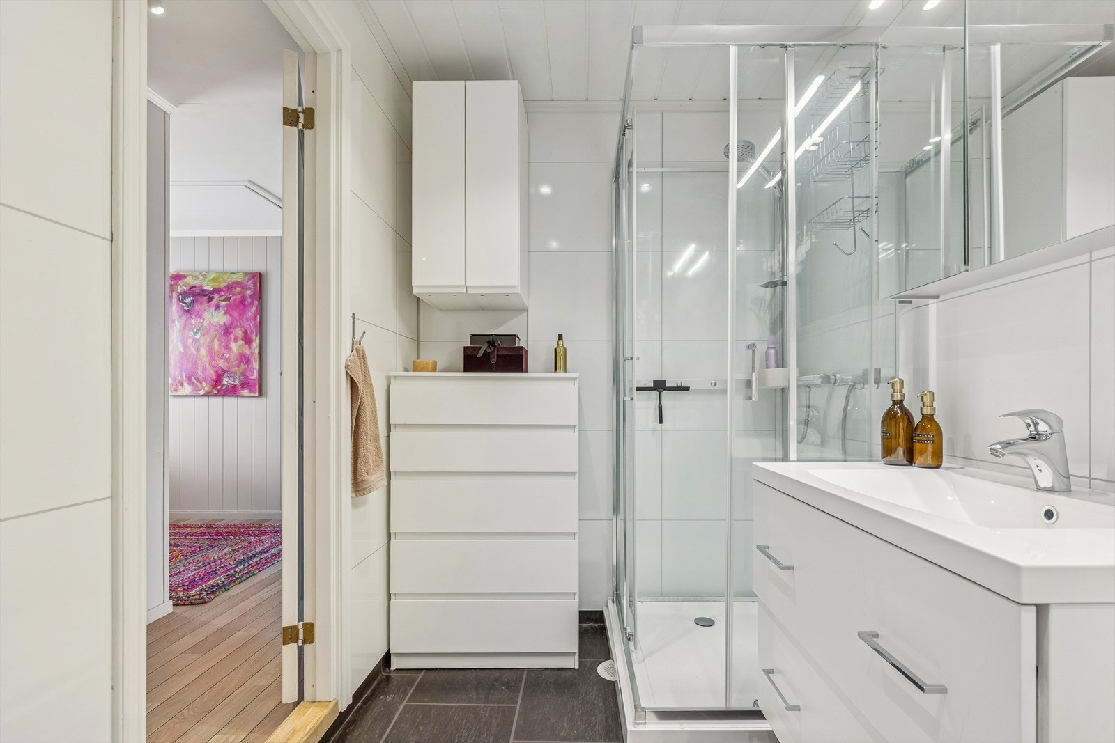 Rommet er utstyrt med dusjkabinett (2022), servantskap og speilskap (2022) for oppbevaring. Galleribilde