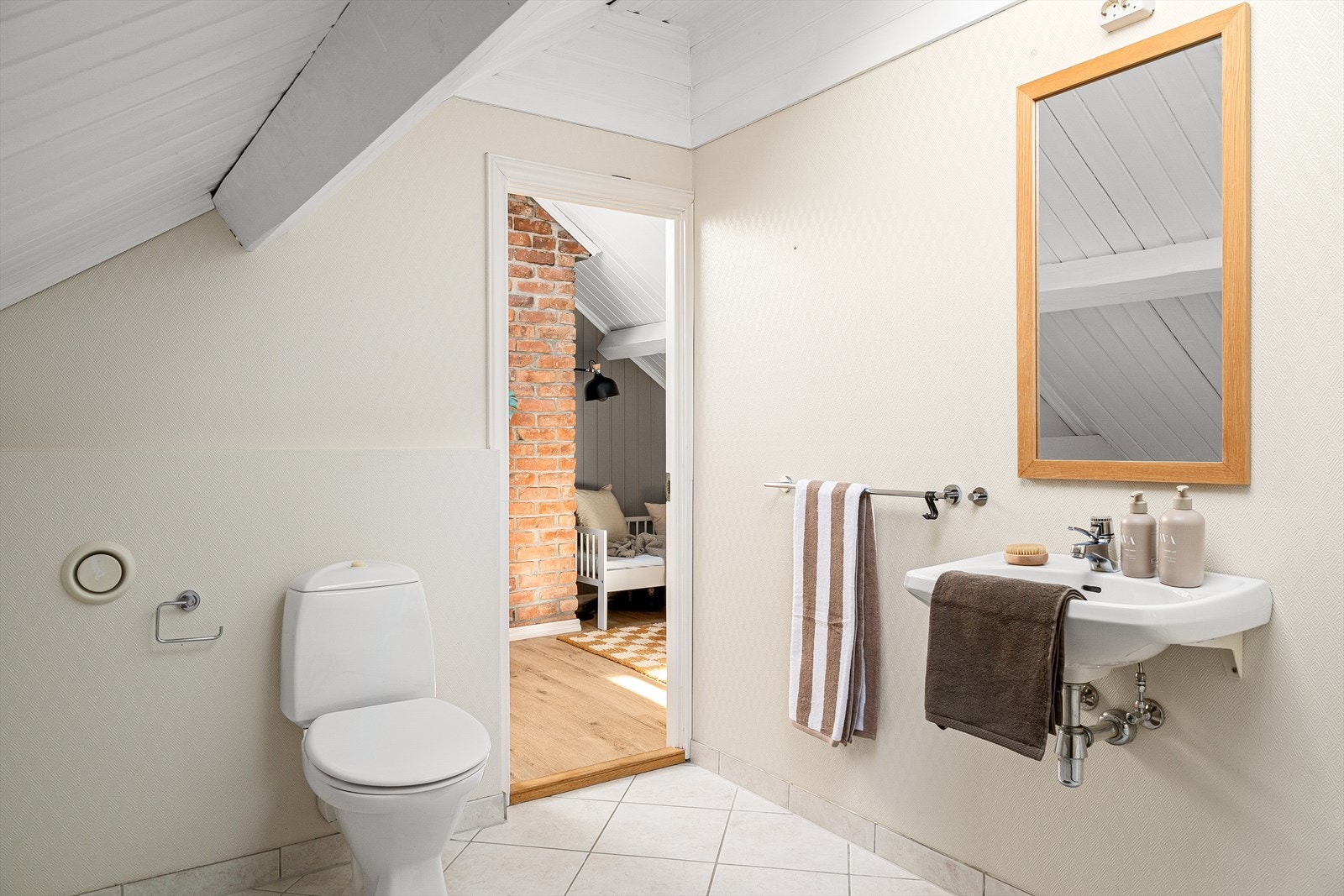 Badet har fliser på gulv og er innredet med toalett, servant og badekar med dusjmulighet. Galleribilde