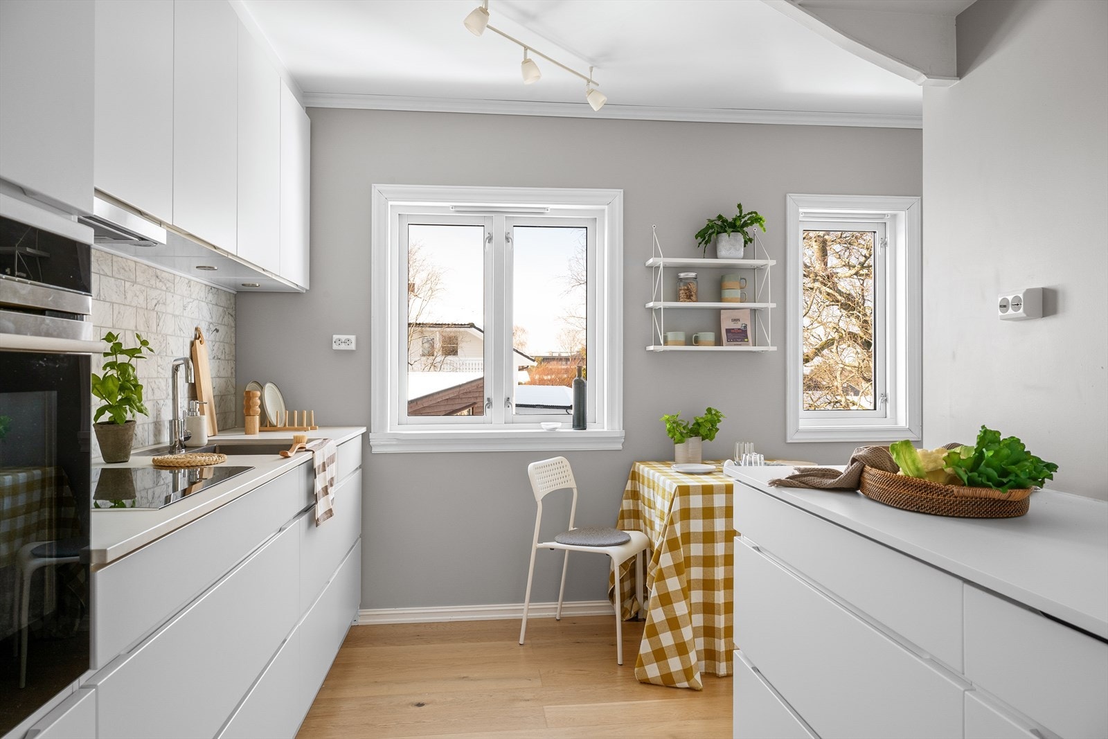 Løsningen er både stilren og funksjonell, med rikelig benke- og skapplass samt plass til et lite frokostbord. Galleribilde