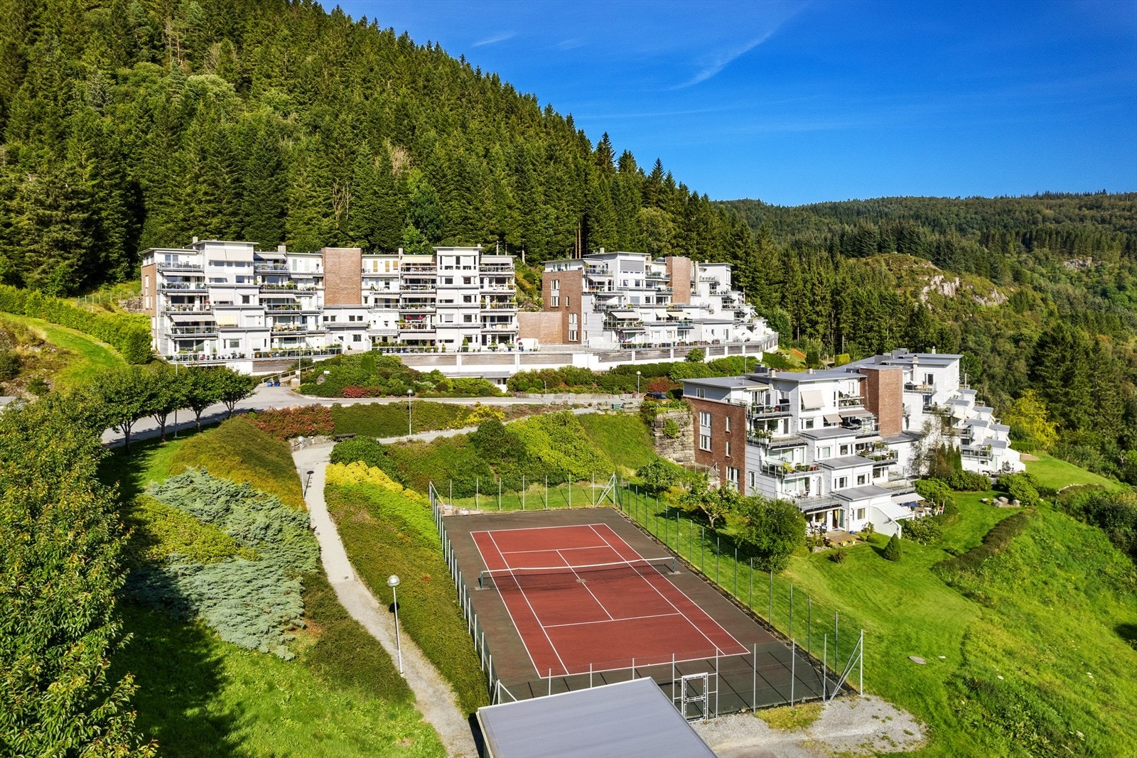 Tennisbane på fellesområde. Fellesområdet er parkmessig opparbeidet. Galleribilde