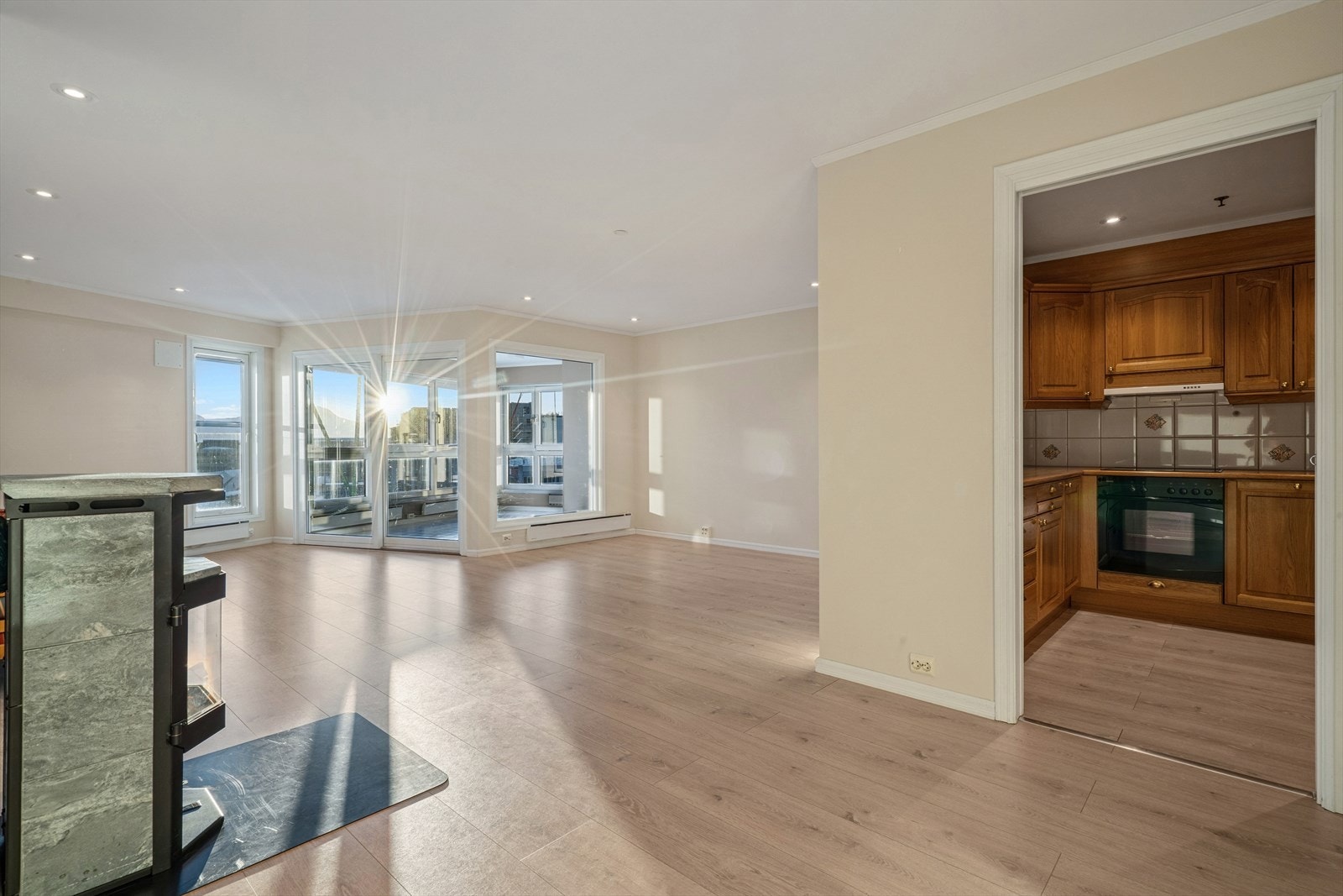 Leiligheten byr på en lys og romslig stue med malte plater på veggene og laminat på gulvet. Galleribilde