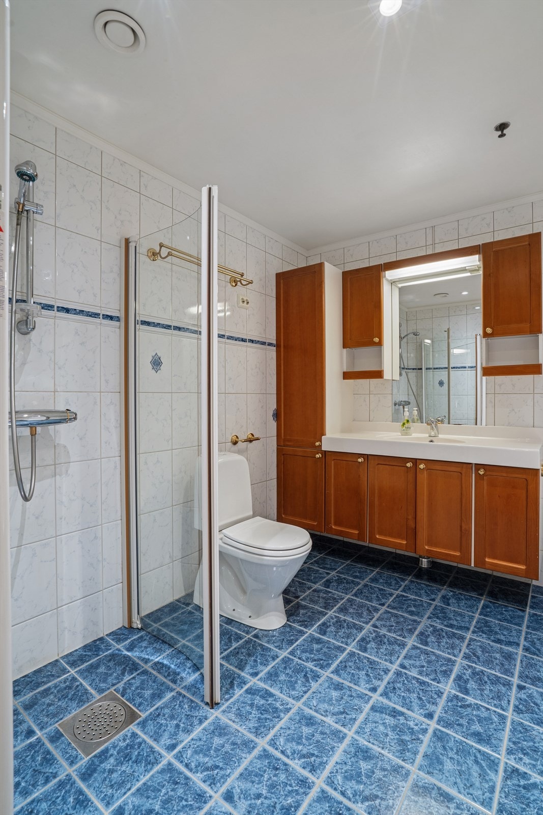 Det er fliser på både vegger og gulv, samt elektriske varmekabler i gulvet. Galleribilde