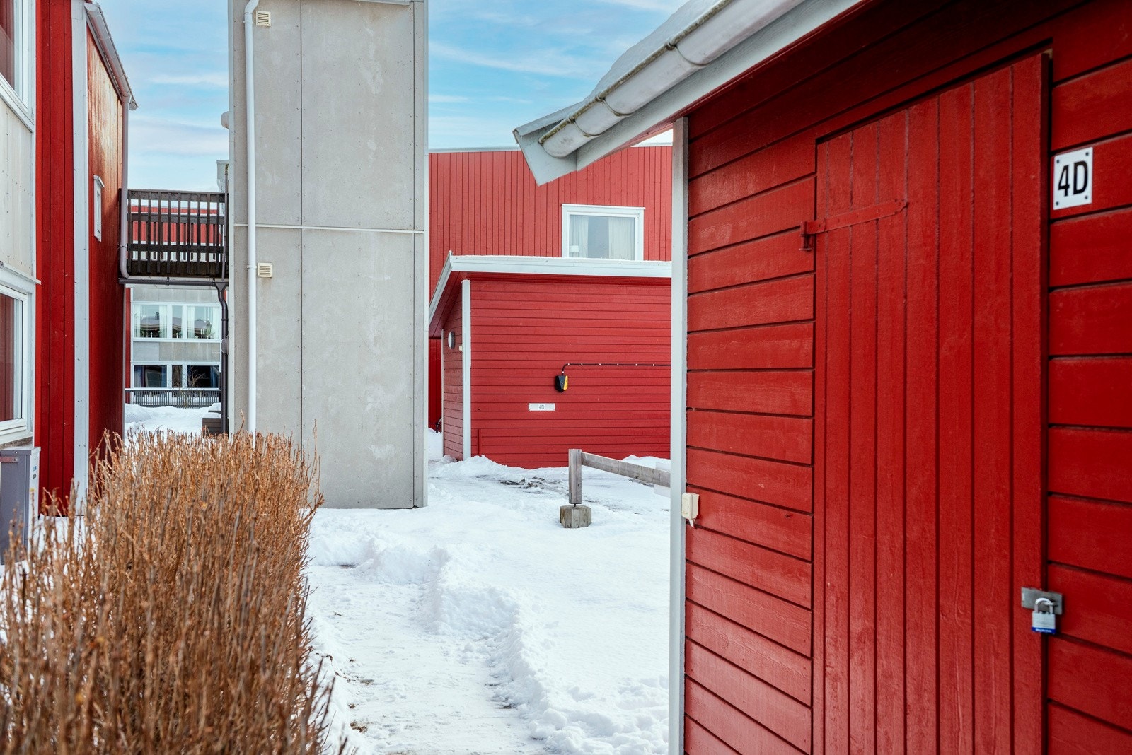 Utvendig bod. Leilighetens parkeringsplass ses i bakgrunnen. Galleribilde