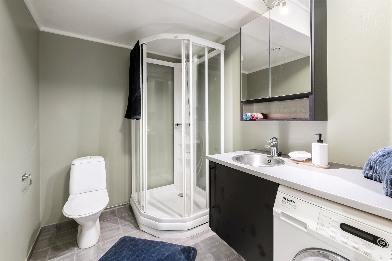 Lyst bad/vaskerom med flislagt gulv og behagelige varmekabler. Galleribilde