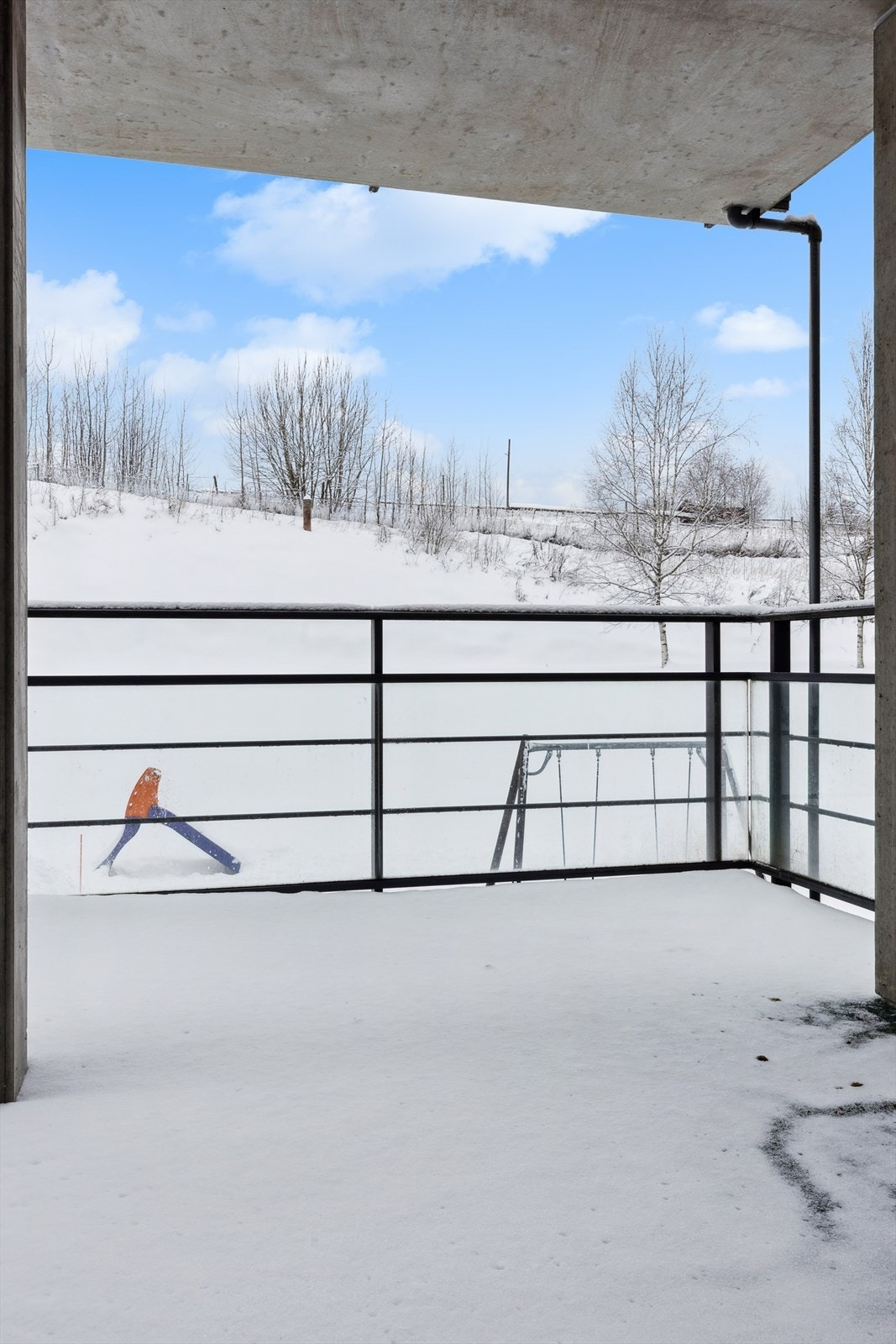 Balkongen er utført i en solid betongkonstruksjon med rekkverk i stål og glass. Legg merke til den flotte utsikten man har opp mot hestene som koser seg på Mo gård. Galleribilde