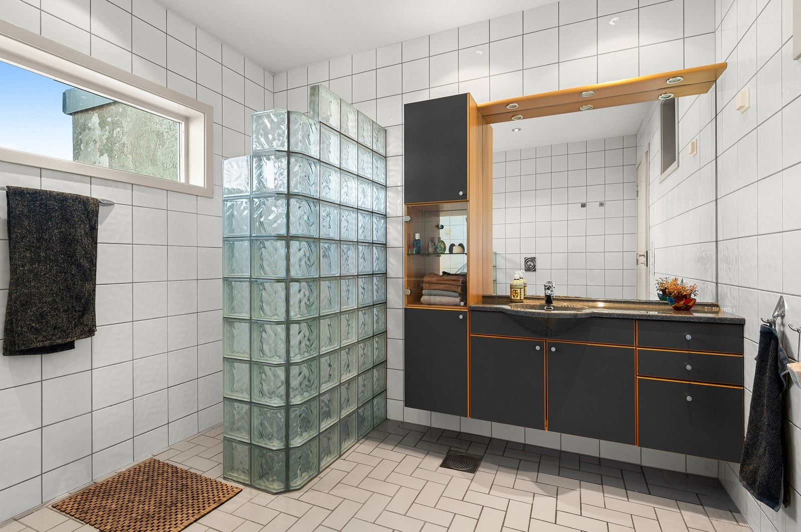 Bad/vaskerom i hovedetasje på 9m2 dusjnisje i glassbyggerstein, fra dusjen nytes utsikt mot fjorden. Galleribilde