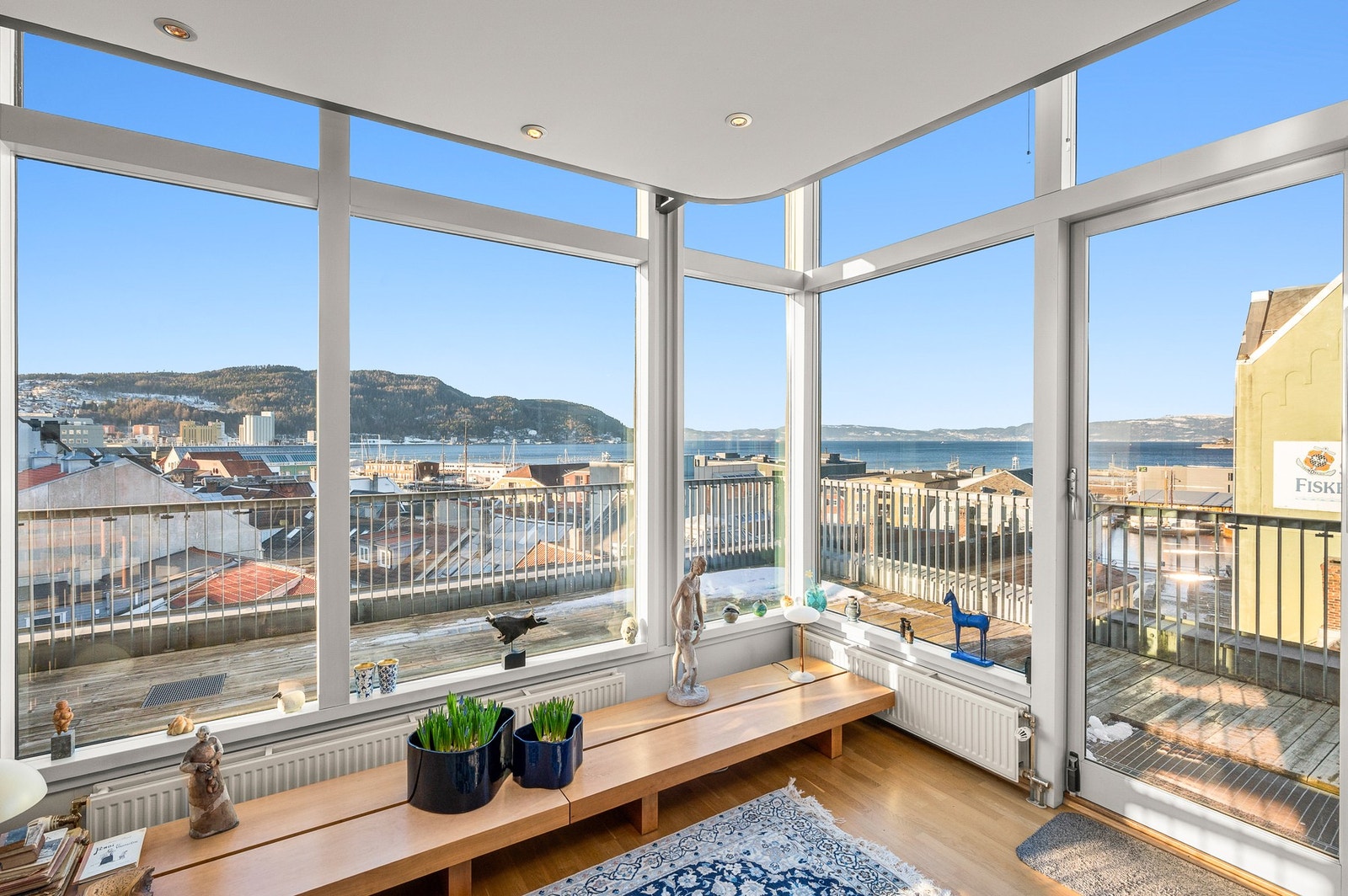 Blikkfanget i stuen er de store vinduene som åpner opp for fantastisk utsikt mot bla. Våttåkammen, Munkholmen og fjorden. Galleribilde