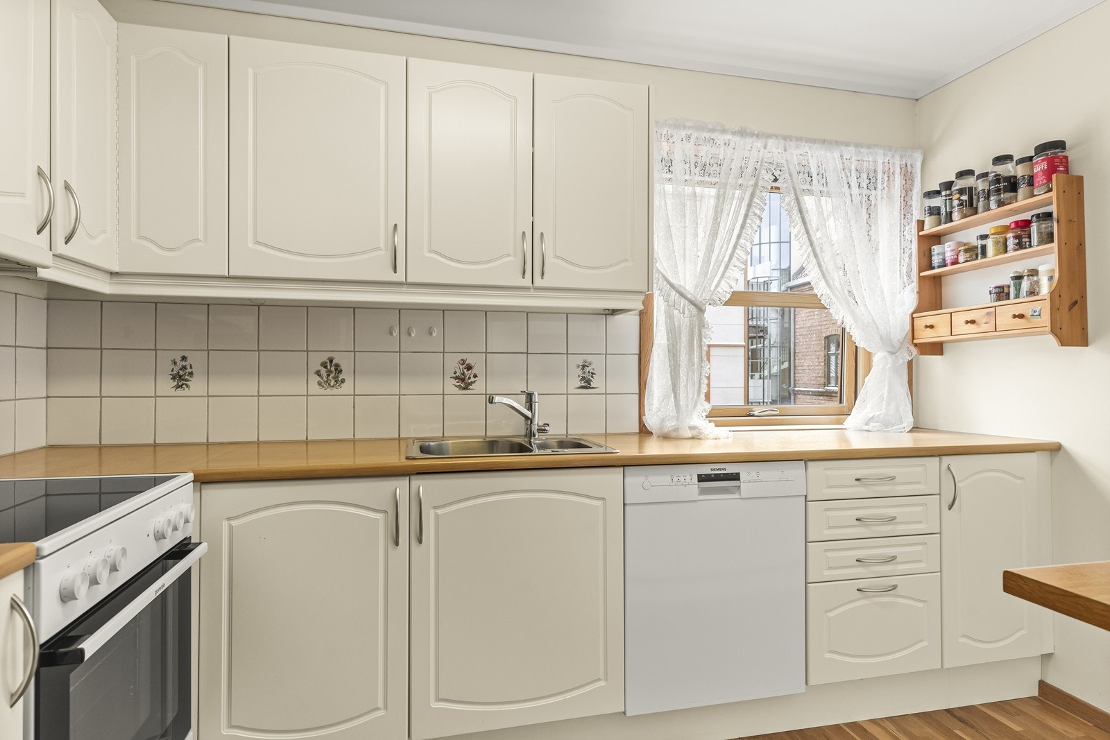 Kjøkkenet har en praktisk innredning fra byggeåret, med over- og underskap som gir rikelig med lagringsplass. Galleribilde