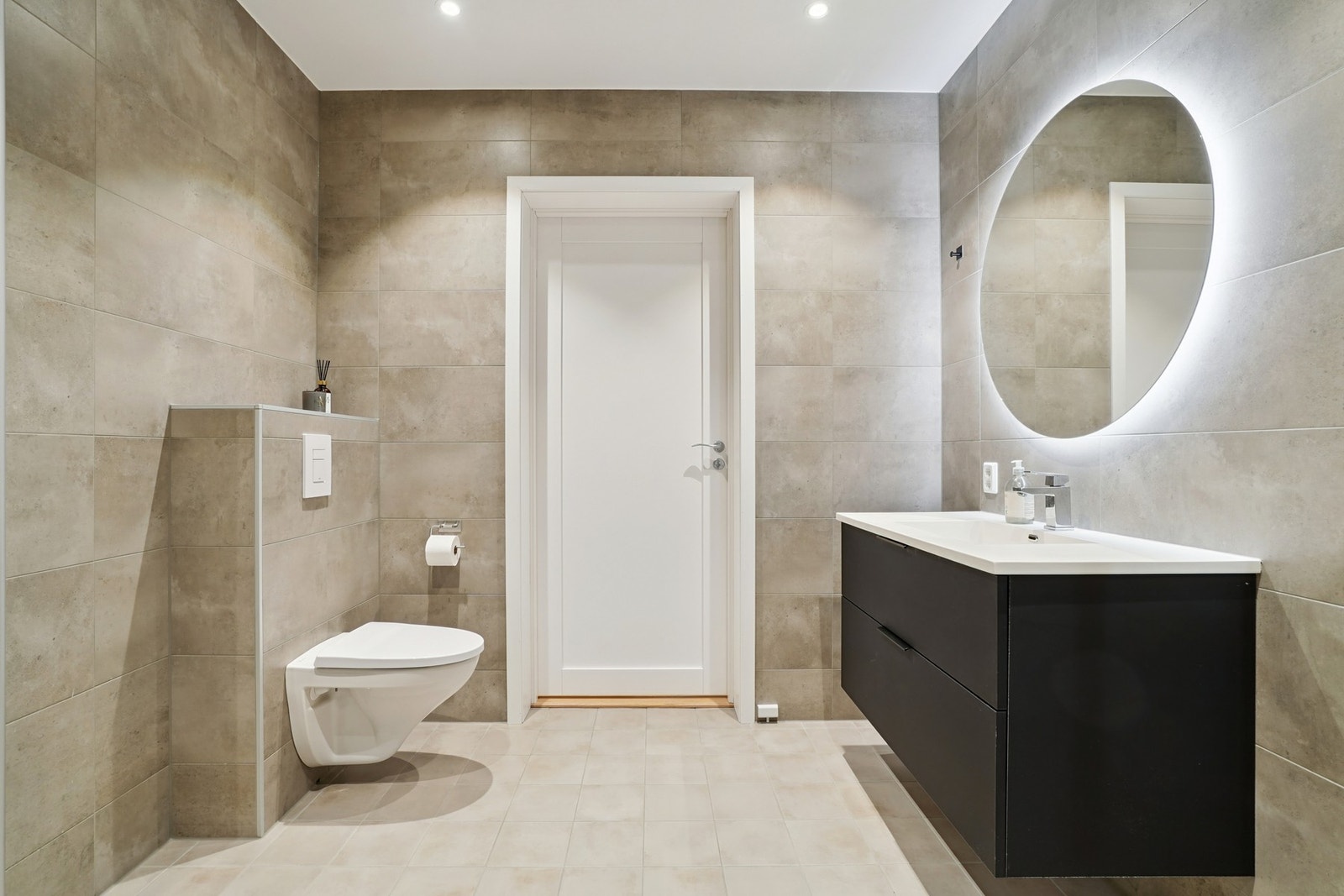 Innredet med vegghengt toalett, dusjhjørne med glassdører. Galleribilde