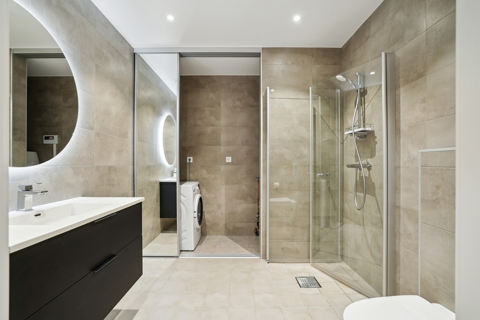 Delikat helfliset bad kombinert med vaskerom. I himling er det ledspotter med dimming. Galleribilde