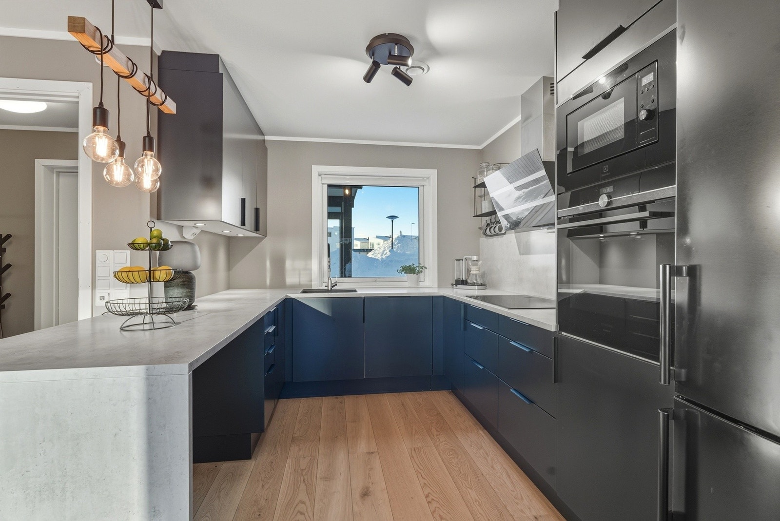 Lekkert kjøkken fra Sigdal med mørke slette fronter og benkeplate av laminat. Spotter under overskap. Galleribilde