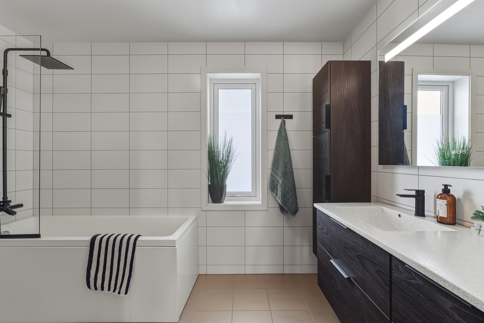 Romslig og pent flislagt bad med varme i gulv og badekar. Galleribilde