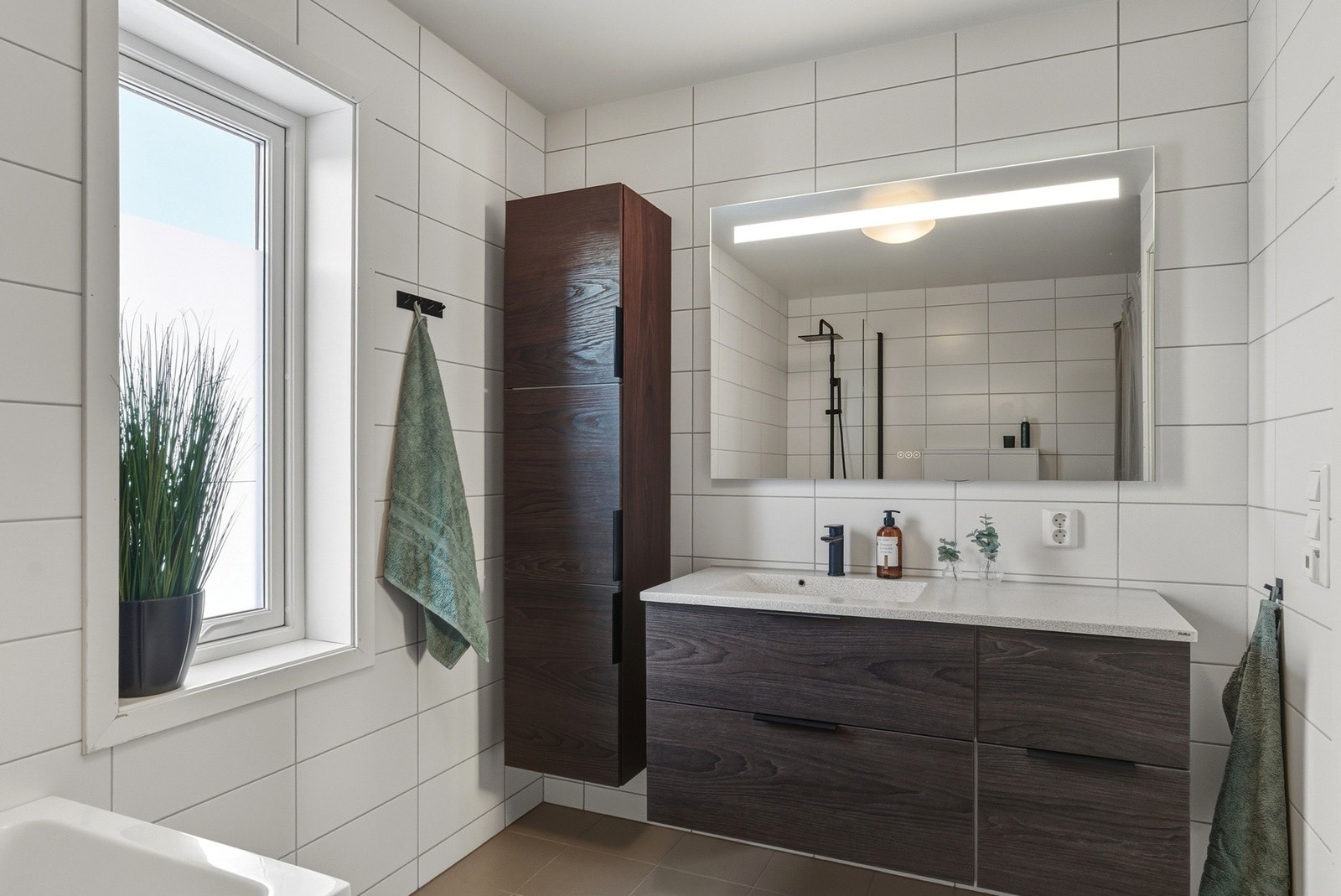 Servantinnredning med skuffer og høyskap. Stort speil med integrert led-lys. Galleribilde