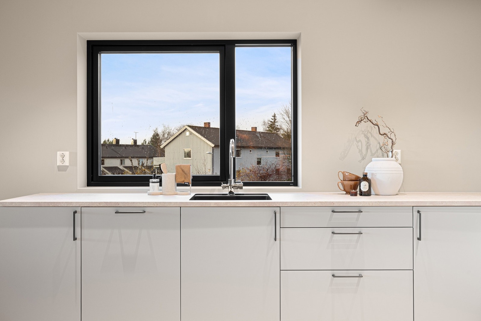 Kjøkkenet har minimalistisk innredning og gode veggflater for hyller eller dekor. Galleribilde