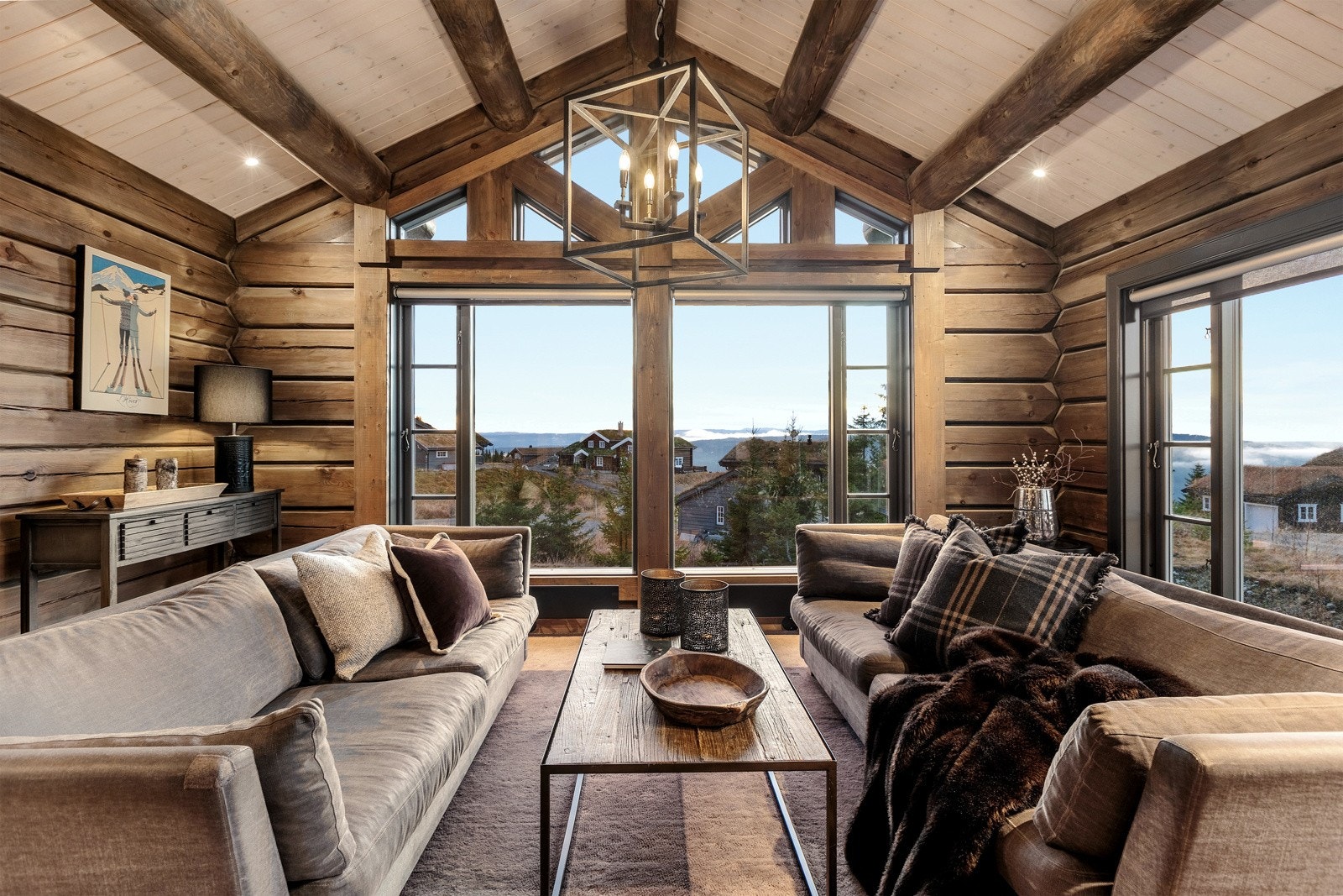 Store vindusflatene i front og takhøyden i stuen gir hytta et eksklusivt uttrykk og innbyr til sosiale sammenkomster med familie og venner. Galleribilde