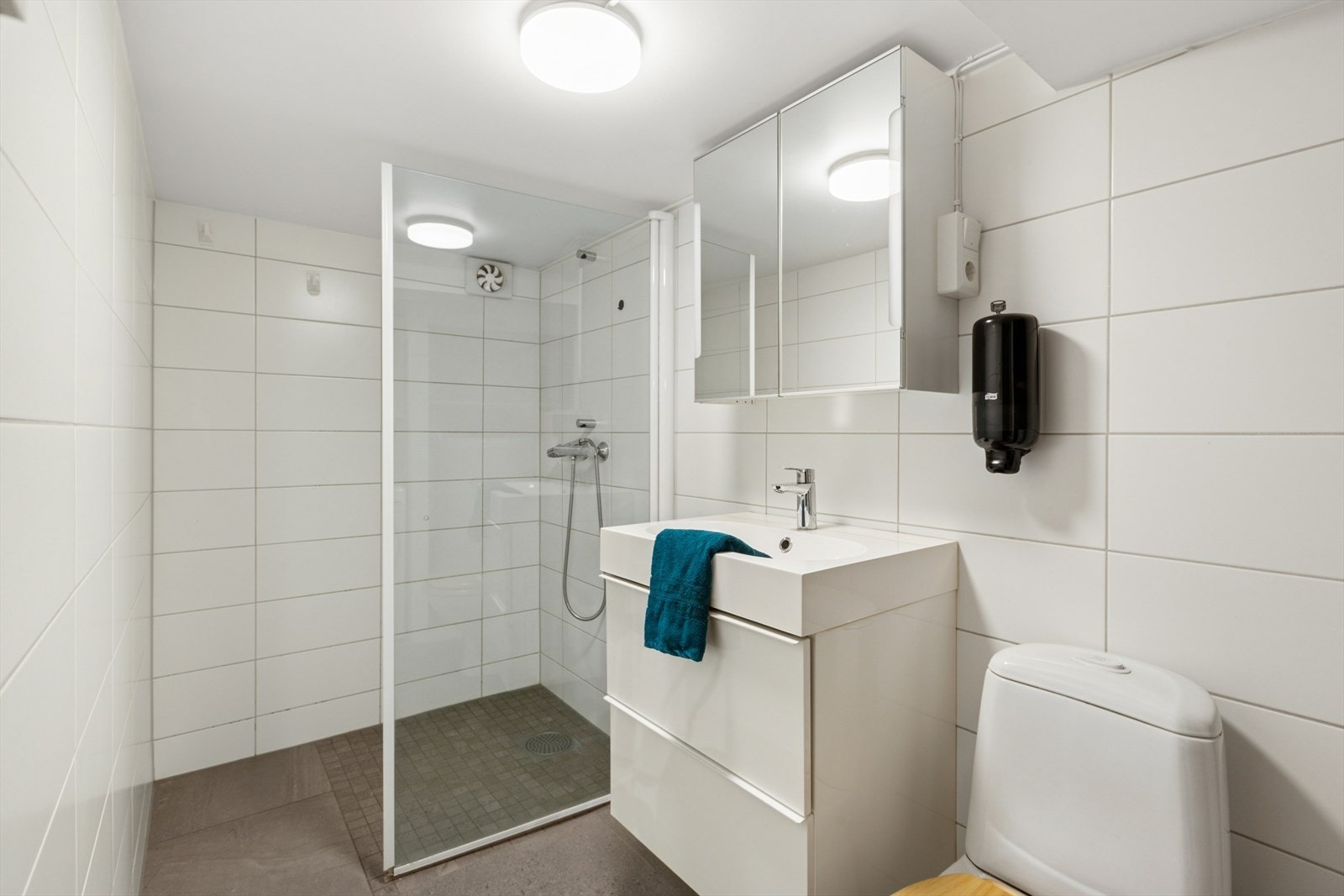 Baderommet i kjeller fremstår særdeles tiltalende og praktisk. Her er det montert dusj, nedfelt servant med underskap og WC Galleribilde