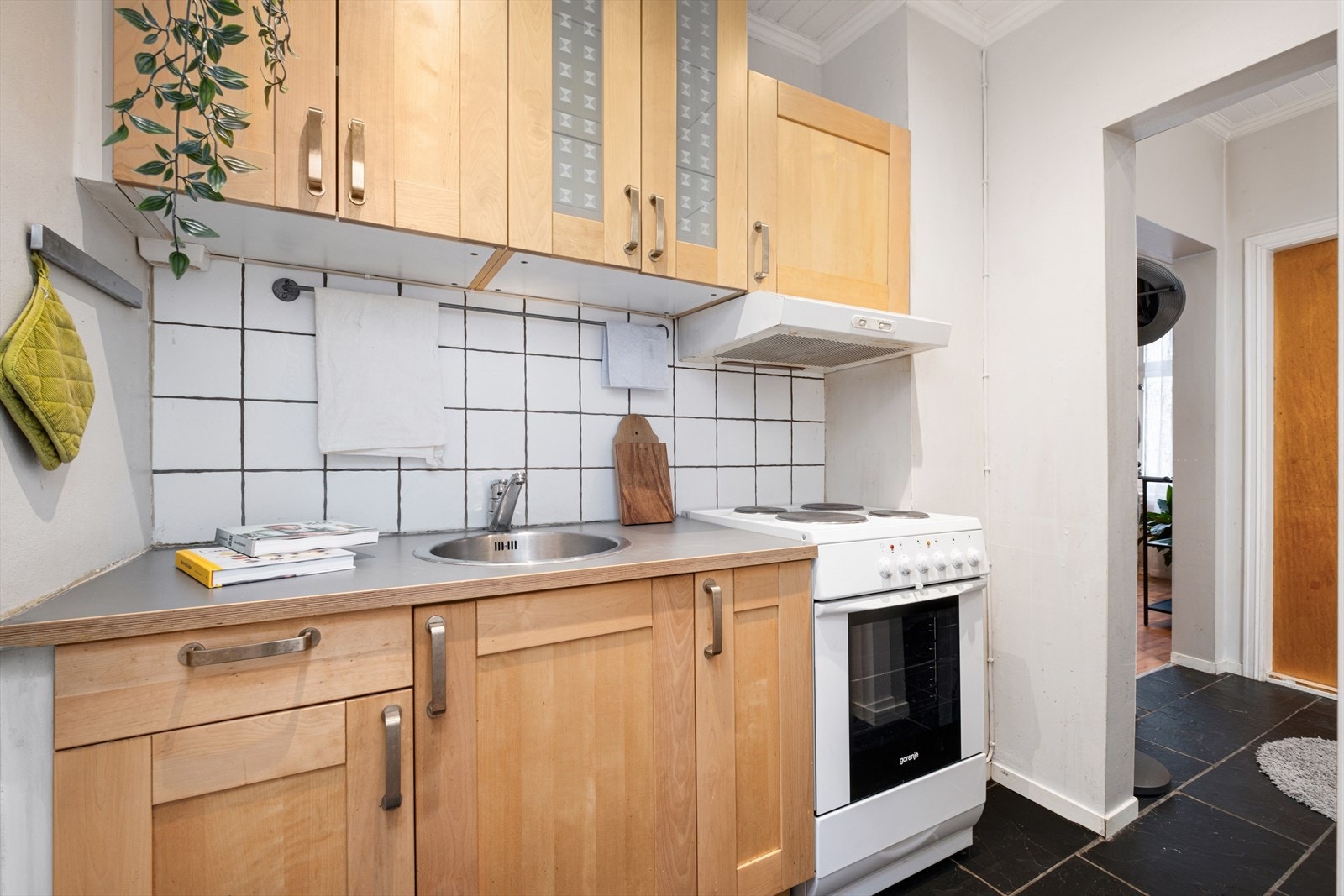 Kjøkkenet med heltre innredning og flislagt gulv. Galleribilde