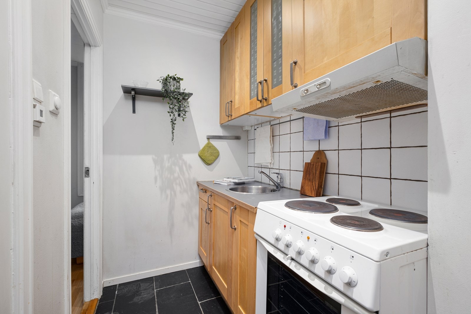 Det er innredet med downlights, kullfiltervifte over stekesonen , samt flis på vegg mellom benkeplate og kjøkkenskap. Galleribilde