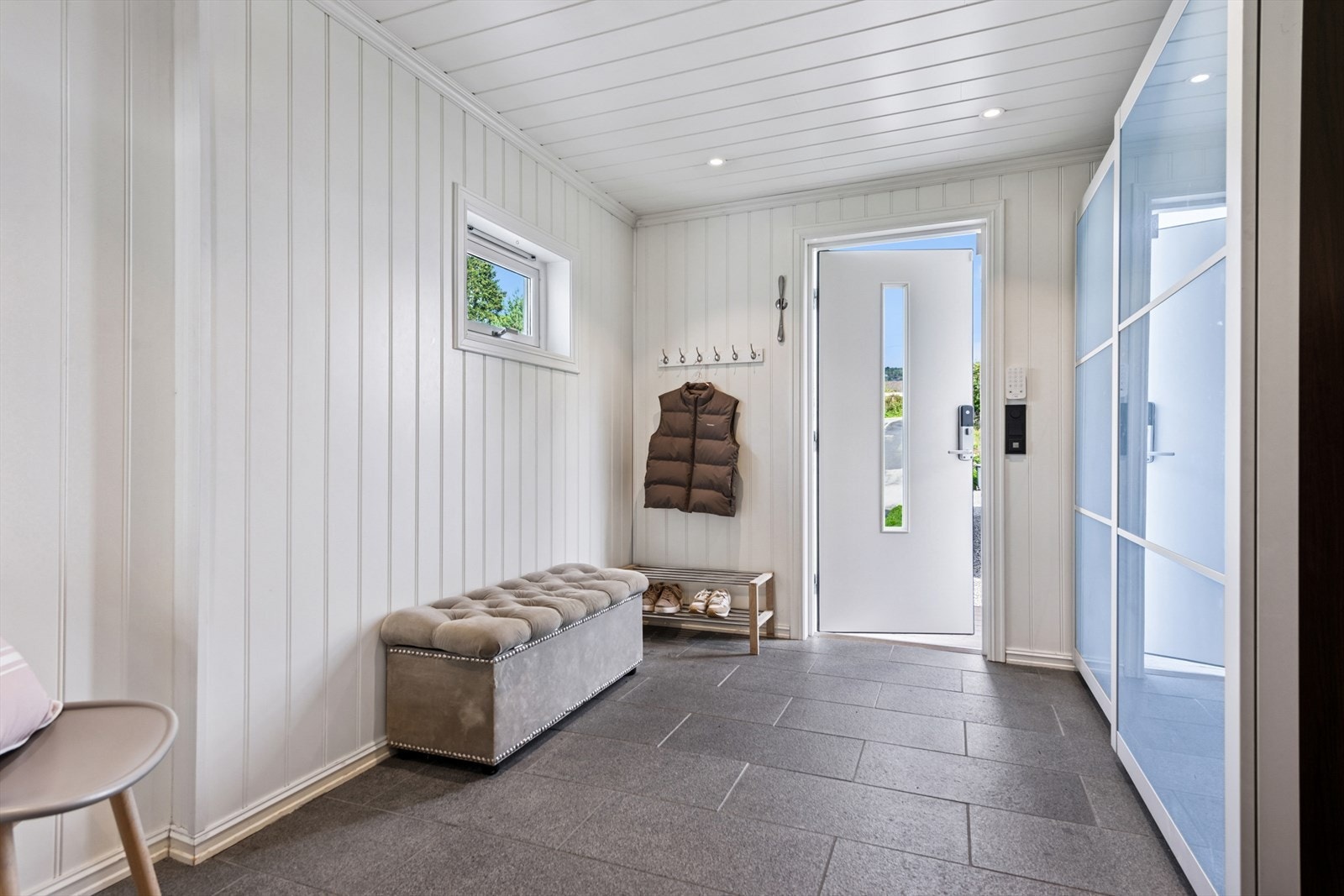Innbydende entré med plass til enkel oppbevaring av yttertøy og sko. Entréen gir et ryddig og oversiktlig førsteinntrykk i det du videre tar deg innover i boligens 1. etasje. Galleribilde