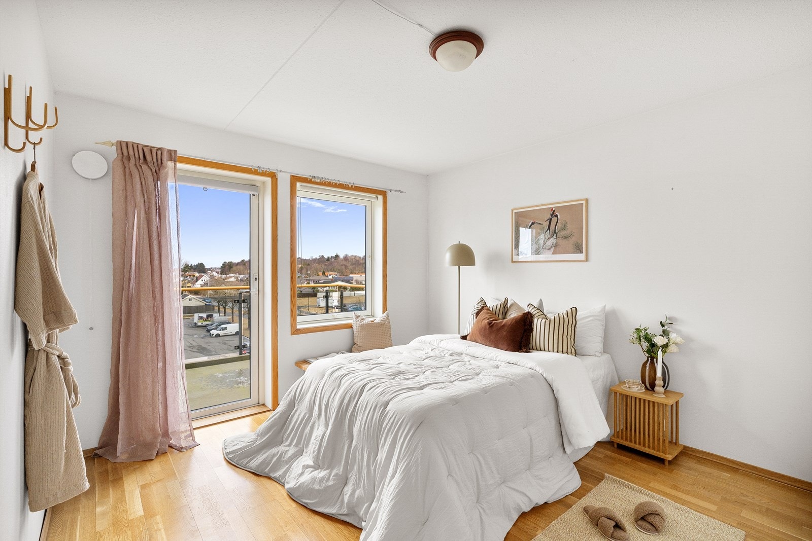 Hovedsoverom med parkett på gulv og lyse vegger. Fra soverom har man tilkomst til en balkong med morgensol Galleribilde