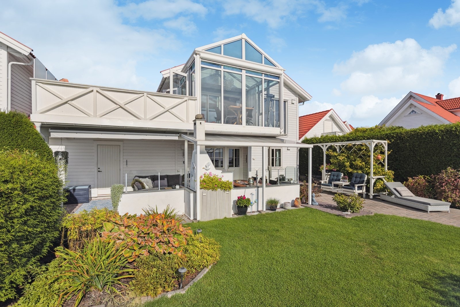 Både bygningsmasse og tomt fremstår som velstelt og godt holdt. Her ses fasaden og hagen mot syd. Galleribilde