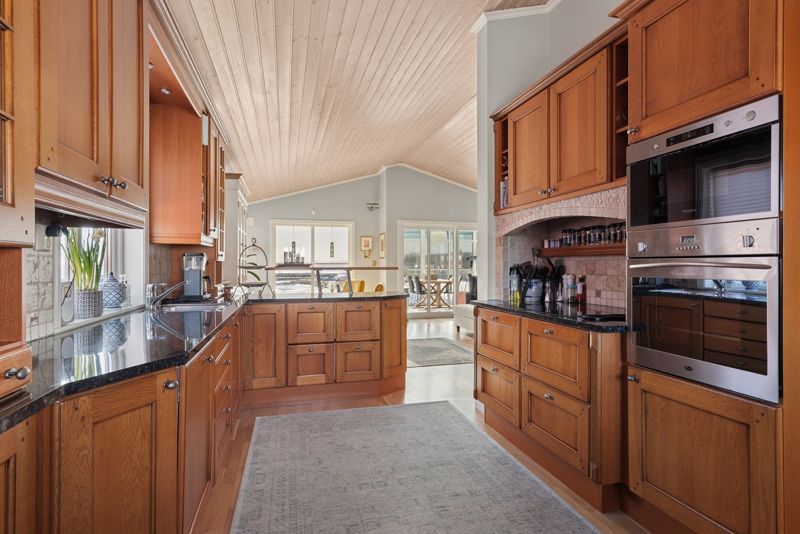 Solid og flott kjøkken med heltre innredning og benkeplater i stein og laminat. Galleribilde