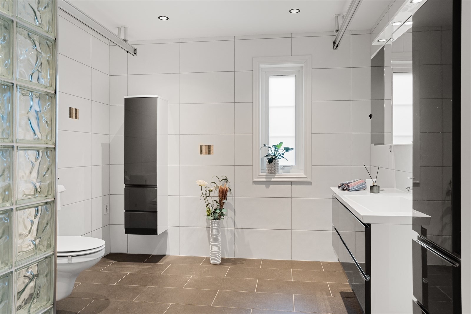 Boligen har et stort og flott bad i 1. etasje med fliser på gulv og vegger - gulvet har også vannbåren gulvvarme Galleribilde