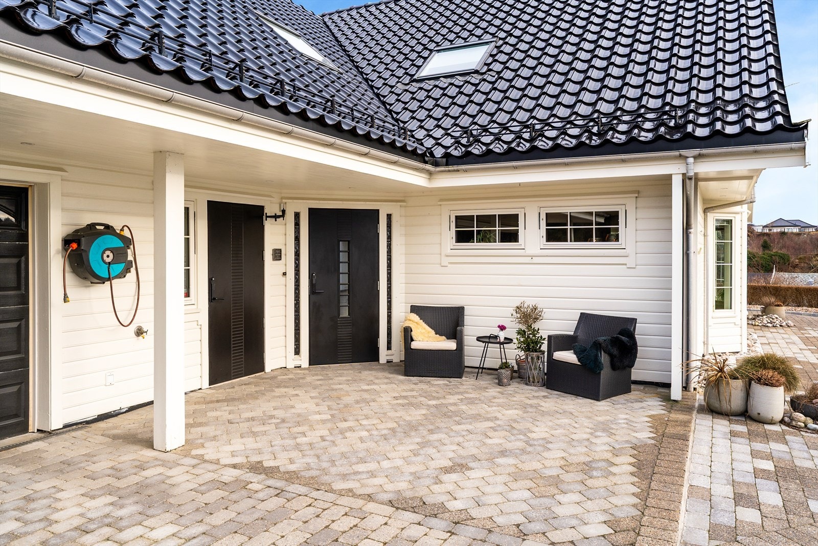 Boligen har et flott og delvis overbygget inngangsparti med dekorativ brostein Galleribilde