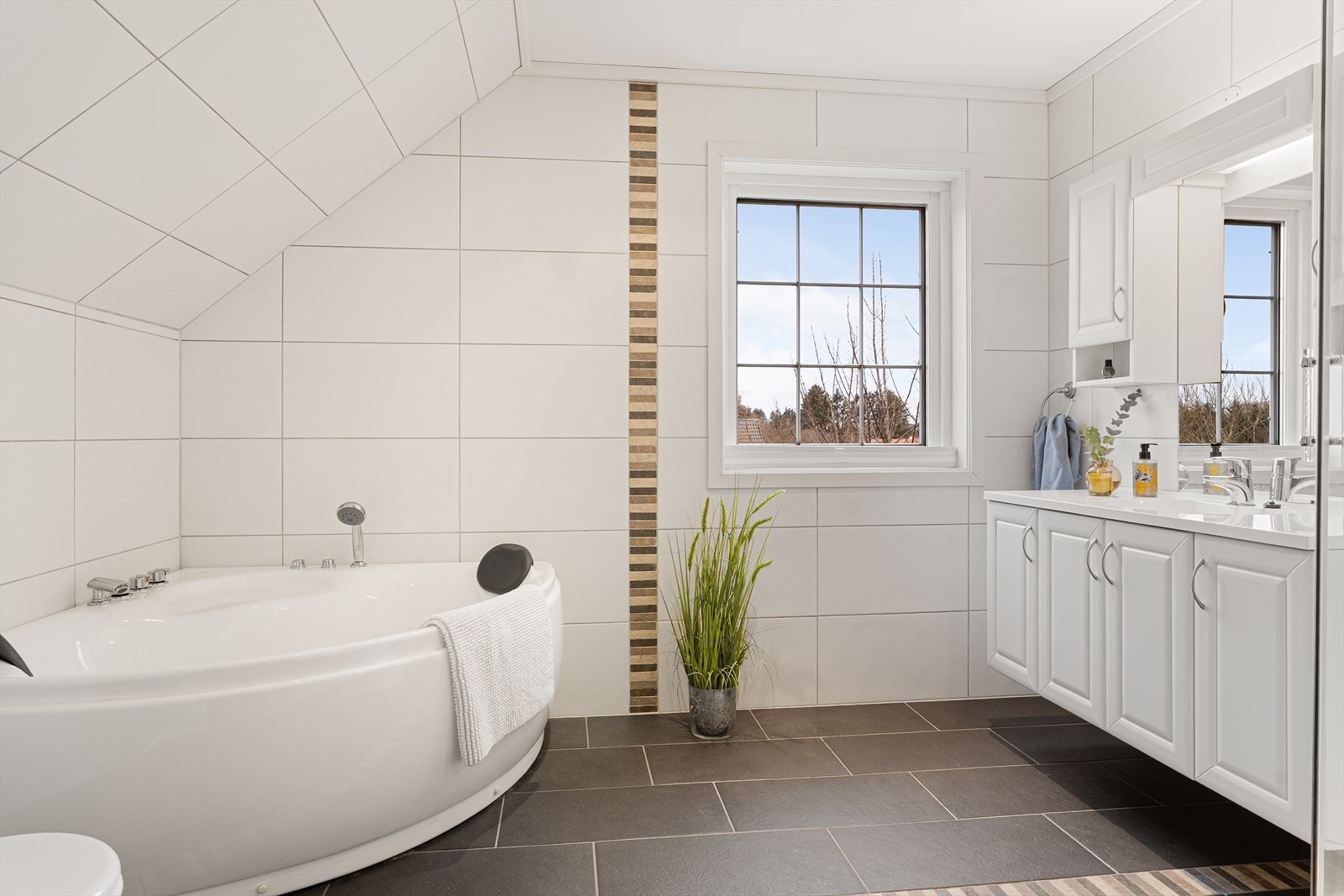 I 2. etasje finner du et lys og pent bad med fliser på gulv og vegger Galleribilde