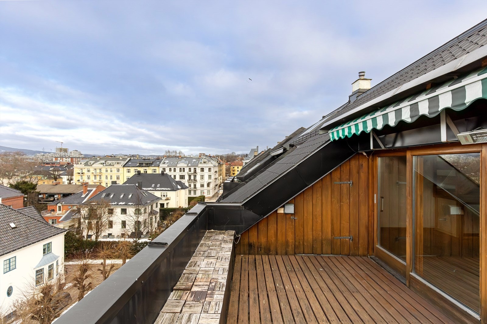 Romslig takterrasse med herlig sol og flott utsikt! Her mot nordøst med utgang direkte fra stue/kjøkken. Praktisk utebod til lagring av utemøbler og puter mm. Galleribilde