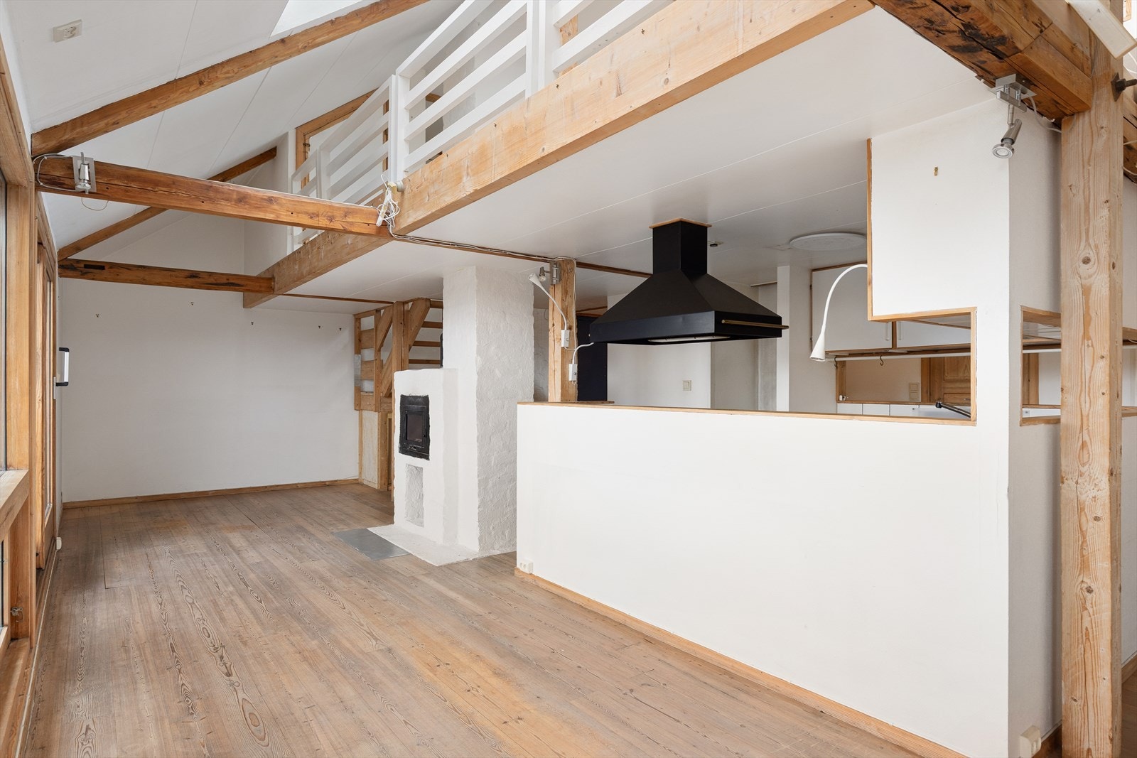 Godt med lys fra de store vinduene, samt spiseplass og peis ved kjøkkenet Galleribilde