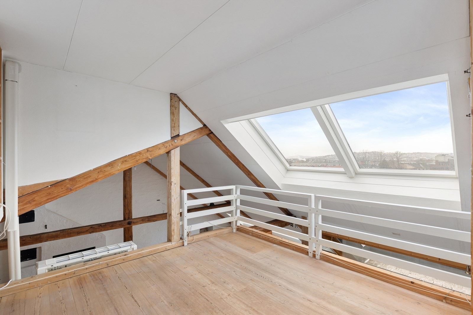 Mezzanin/loftstue med store lysvennlige takvinduer, bod, samt utgang direkte til takterrasse nr. 2 og videre til tårnrommet/atelier Galleribilde