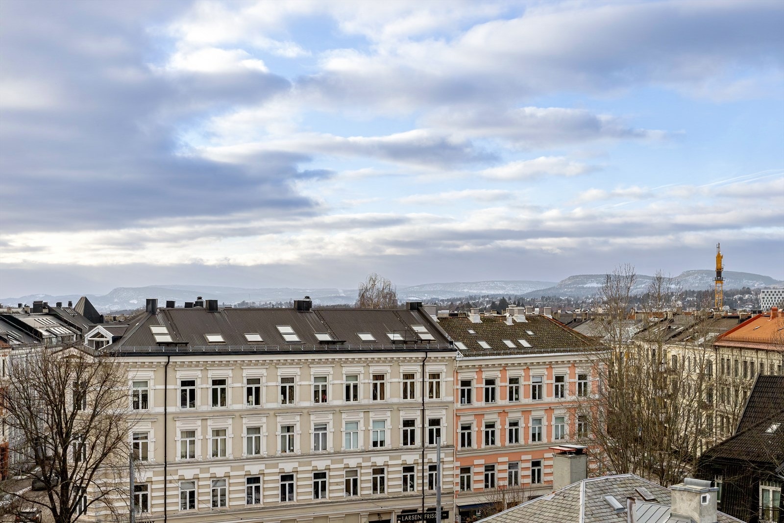 Herlig utsikt over klassisk bygårdsbebyggelse tvers over gaten, samt over nærområdet og åssidene i marka Galleribilde