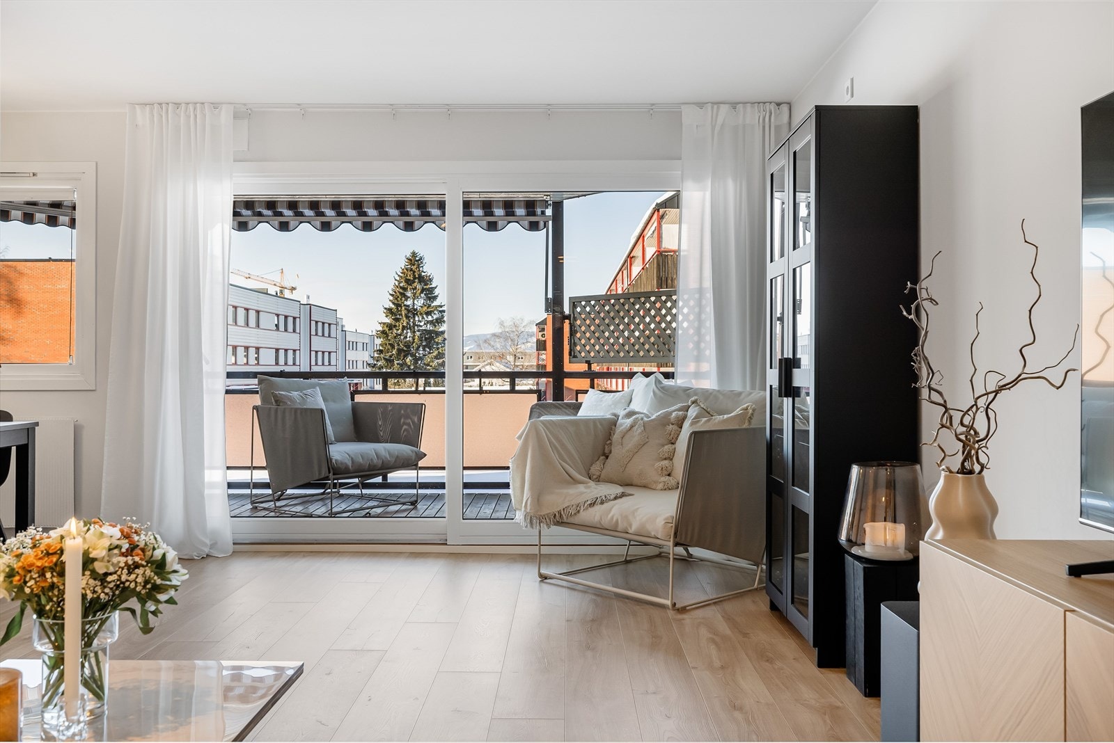 Den har en lys stue med store vinduer som vender ut mot verandaen. Galleribilde