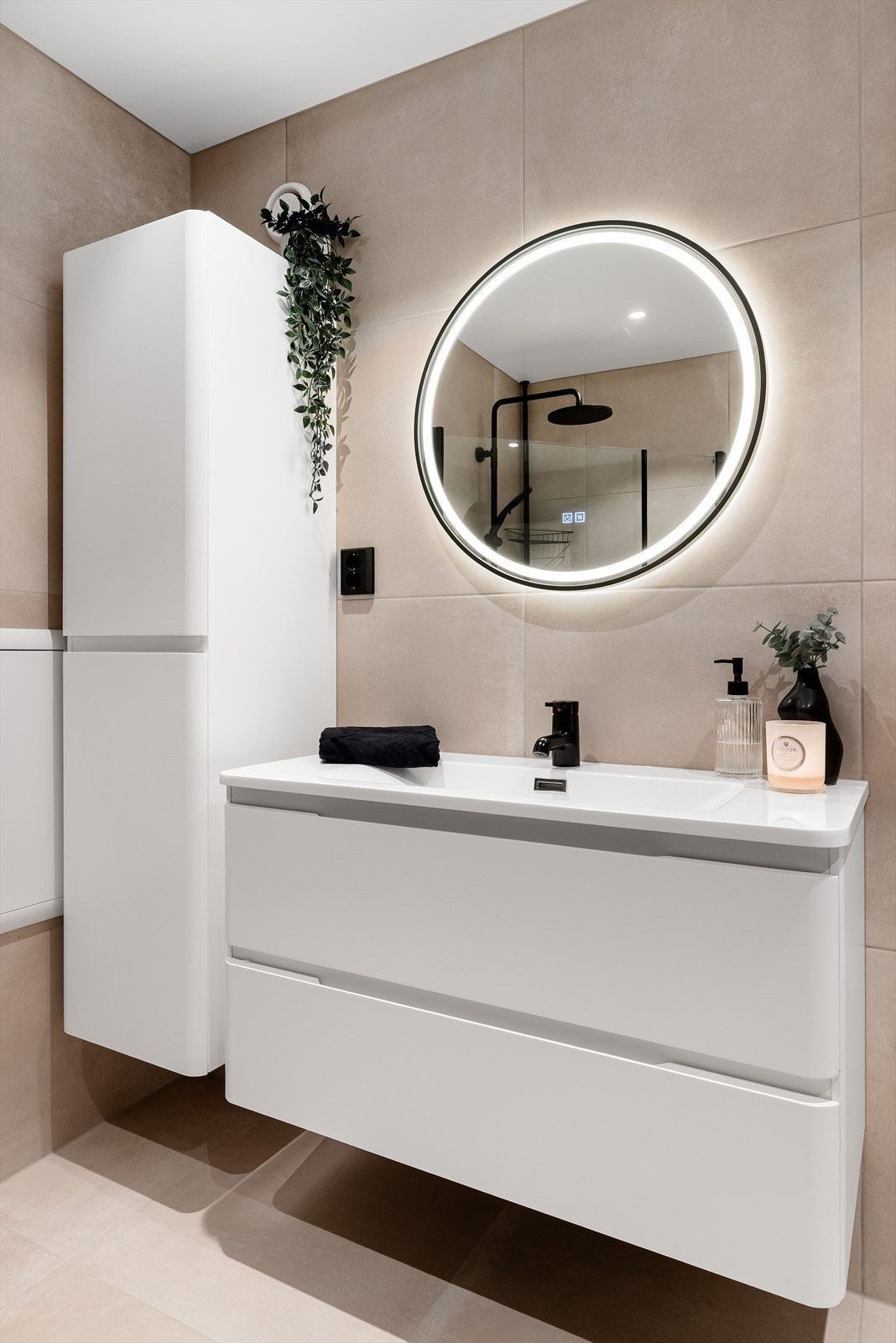 Pen baderomsinnredning bestående av servantskap med skuffer og heldekkende servant, samt et praktisk vegghengt skap. Over servanten er det speil med lys. Galleribilde