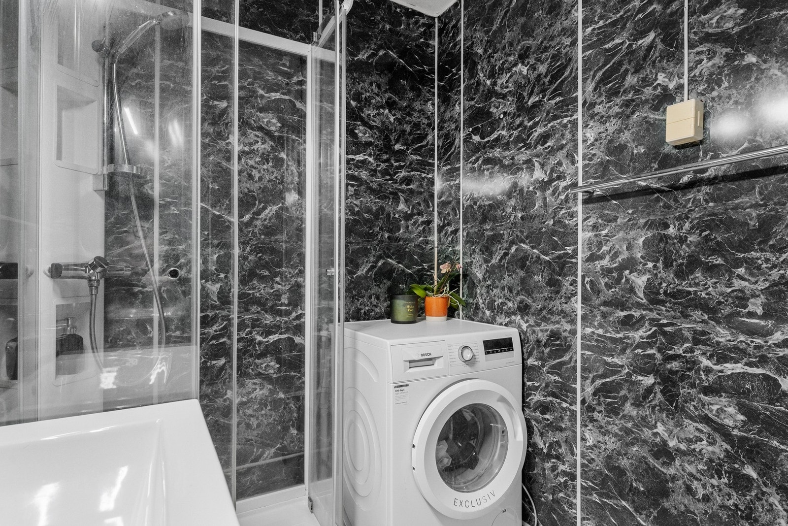 Badet er innredet med dusjkabinett, skap med vaskeservant. Galleribilde