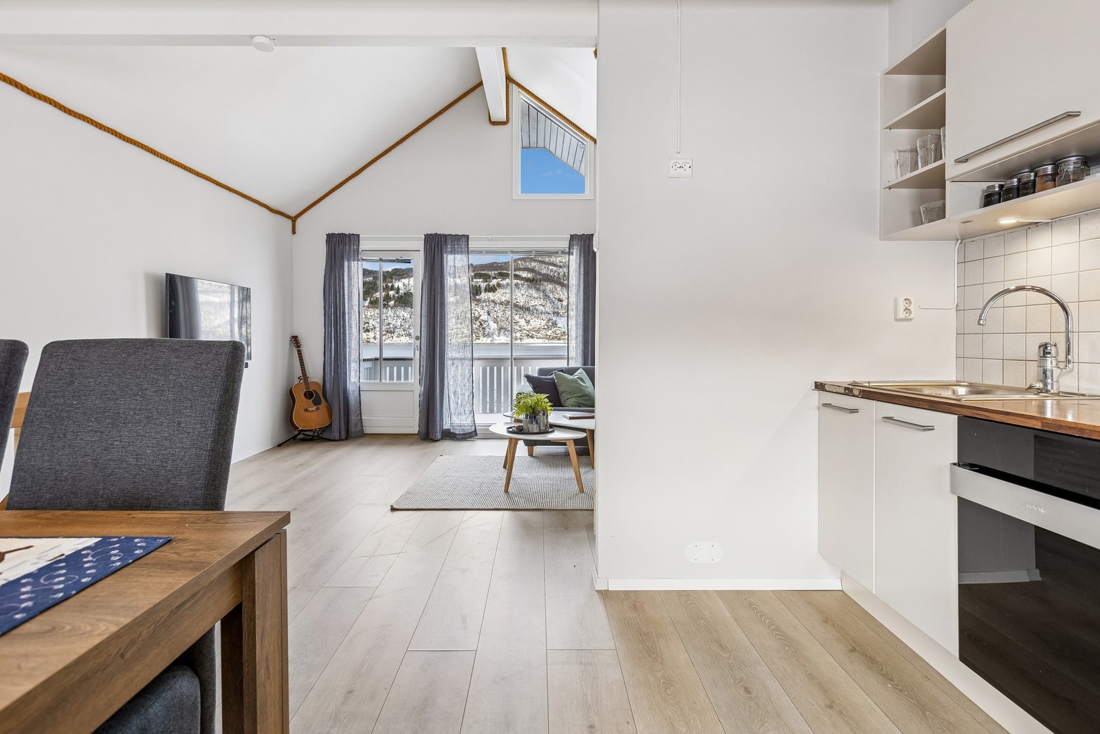 Det er delvis åpen løsning mellom stua og kjøkkenet Galleribilde