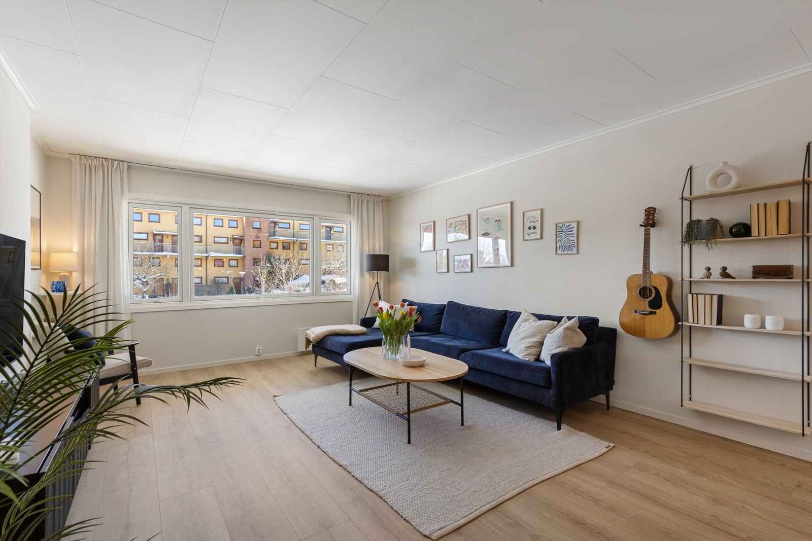 Lys og romslig stue med god takhøyde og store vindusflater som gir en behagelig og åpen atmosfære. Galleribilde