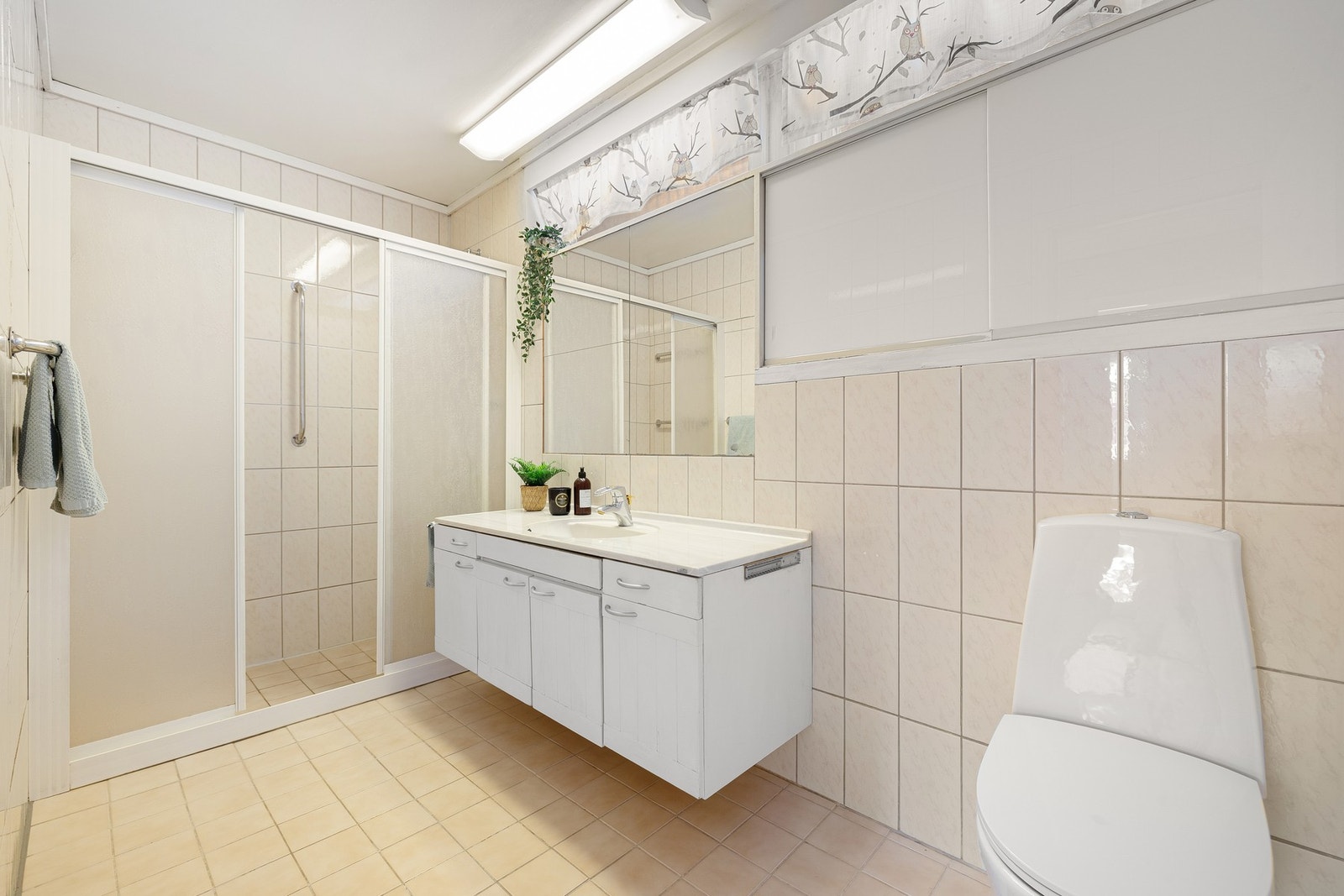 Romslig baderom med behagelig varme i gulvet. Stor dusjnisje og god oppbevaringsplass under servant og i veggskap. Galleribilde