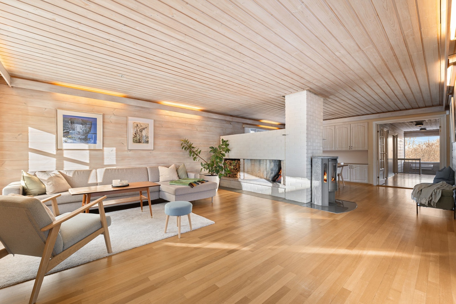 Luftig stue- og spisestueløsning der peisen skaper en god inndeling av rommet. Galleribilde