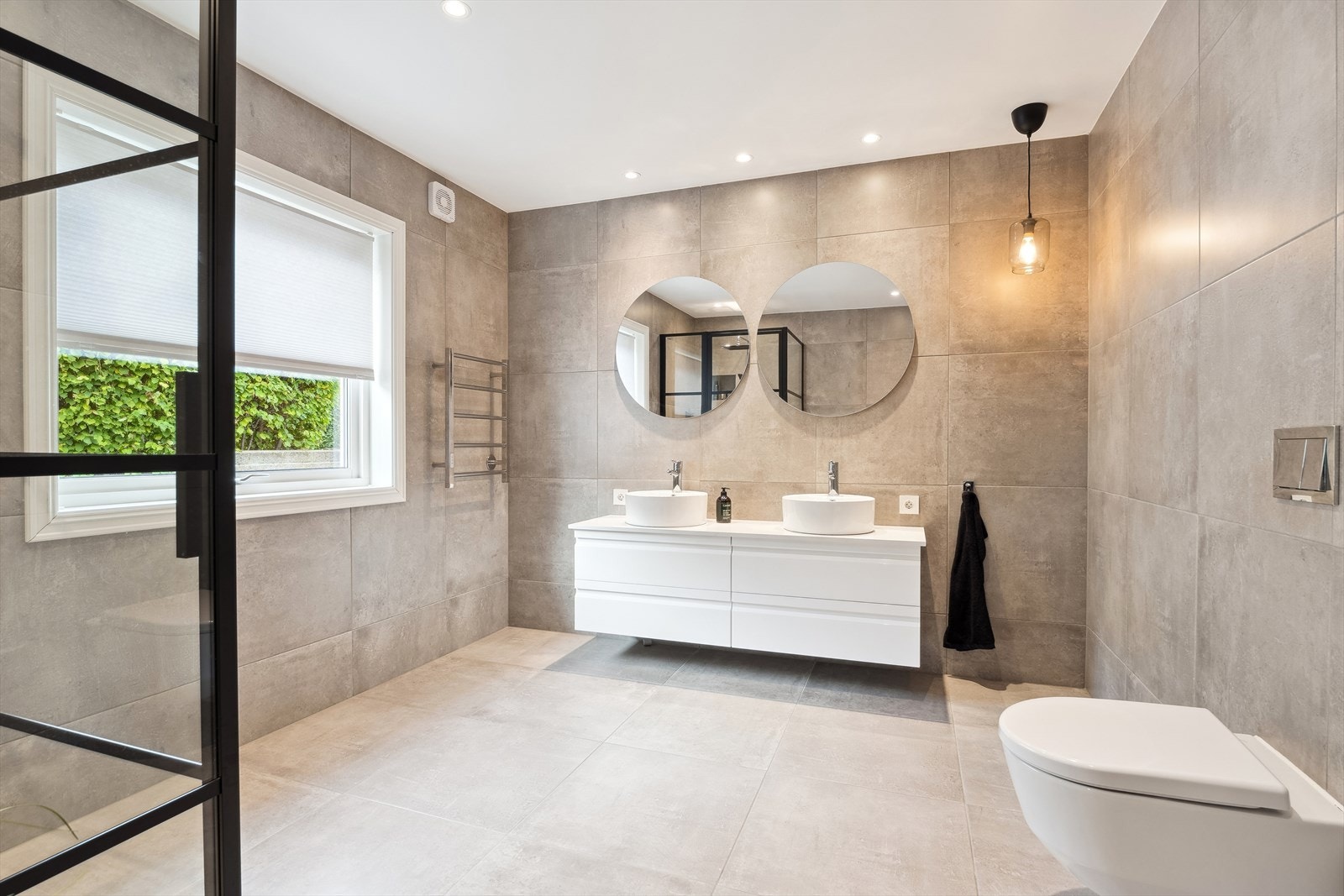 Badet har vegghengt toalett, malt himling med downlights Galleribilde