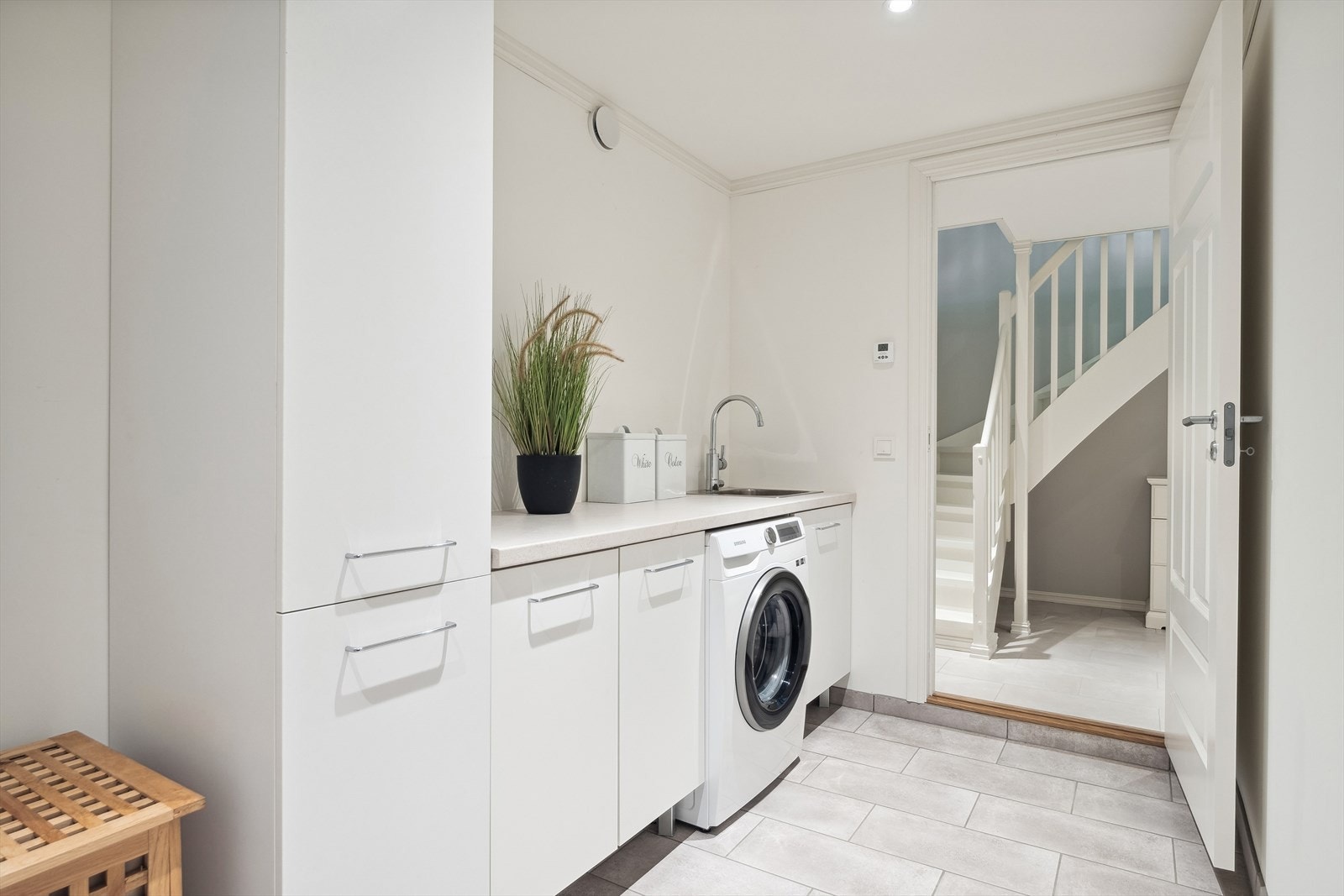 Kjekt vaskerom som har godt med benkeplass og skaper. Fliser på gulv. Galleribilde