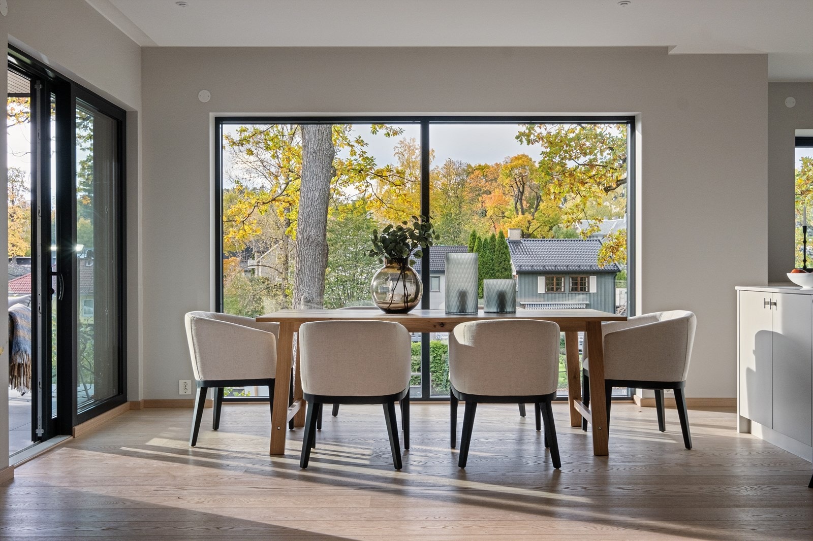 De store vinduene gir en fantastisk stemning, også på kvelden når trærne blir belyst. Bildet er fra leiligheten i 1. etasje. Galleribilde