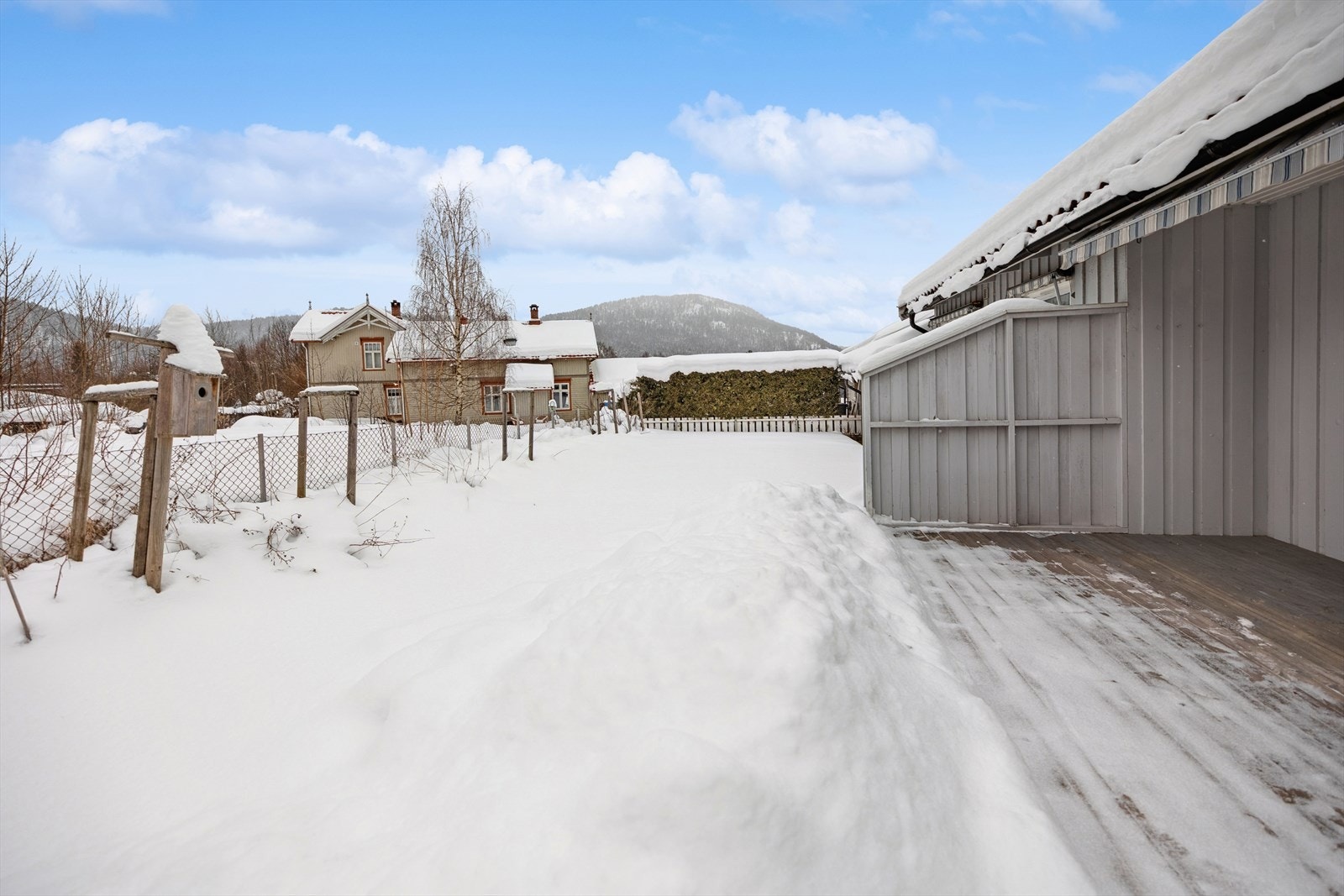 Beplantning og plenområder i hagen. Tomten grenser til et lek/grøntområde i vest. Galleribilde