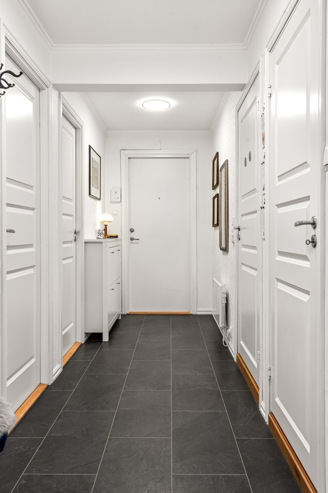 Velkommen inn i en romslig entré som fordeler tilgangen til leilighetens øvrige rom. Galleribilde