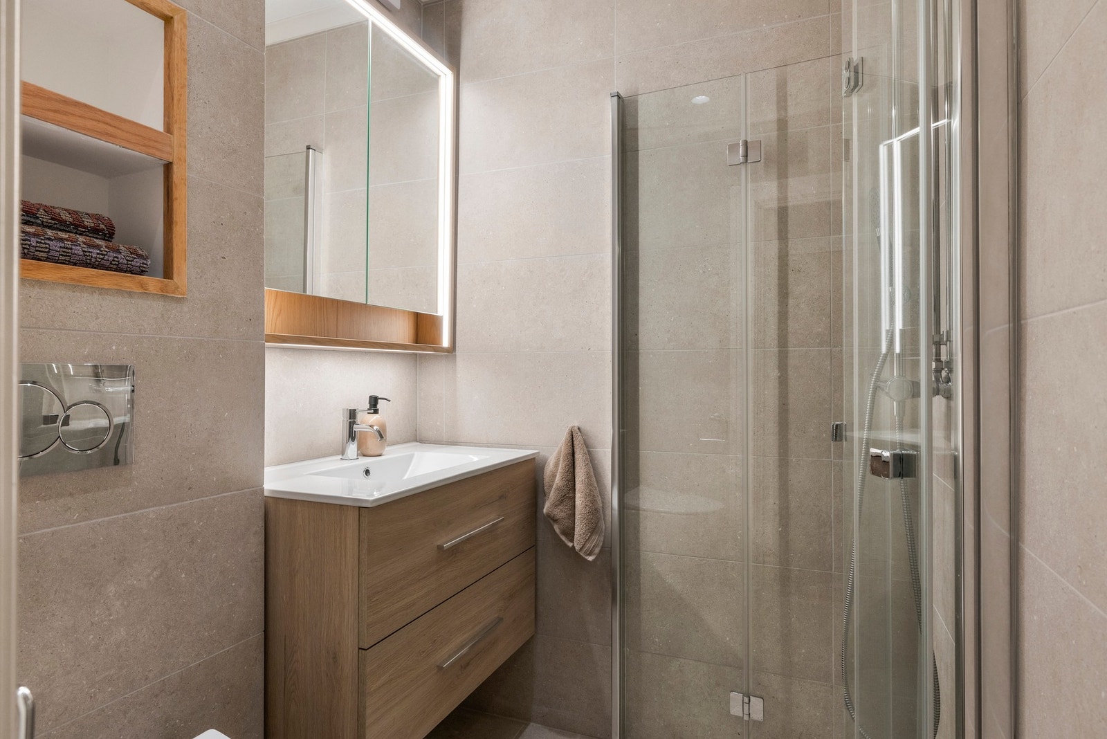 Innredningen består av servant med underskap og tilhørende speilskap, vegghengt toalett samt dusjsone med innsvingbare dører. Dusjsonen er utstyrt med både regnfallsdusj og håndholdt dusj. Galleribilde