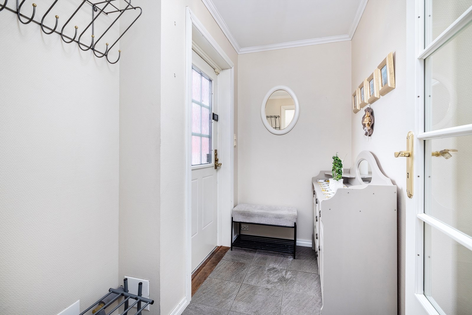 Inngangspartiet har flislagt gulv og plass til oppbevaring av yttertøy. Galleribilde