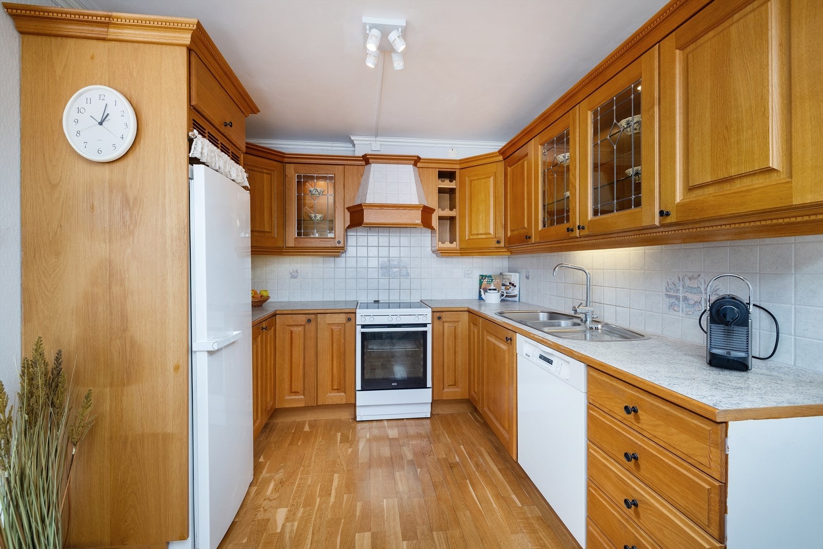 Kjøkkeninnredning med profilerte fronter, laminatbenkeplate og flislagt bakvegg. Galleribilde