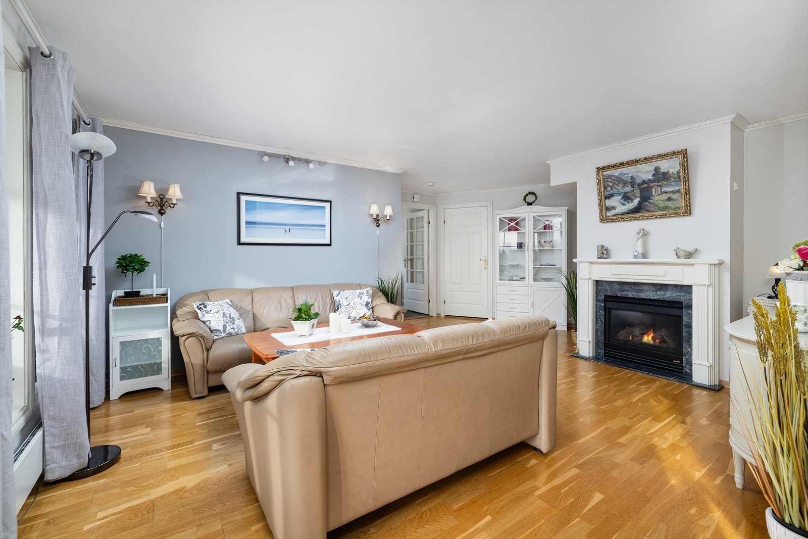 Romslig stue fungerer som et naturlig samlingspunkt i leiligheten. Galleribilde